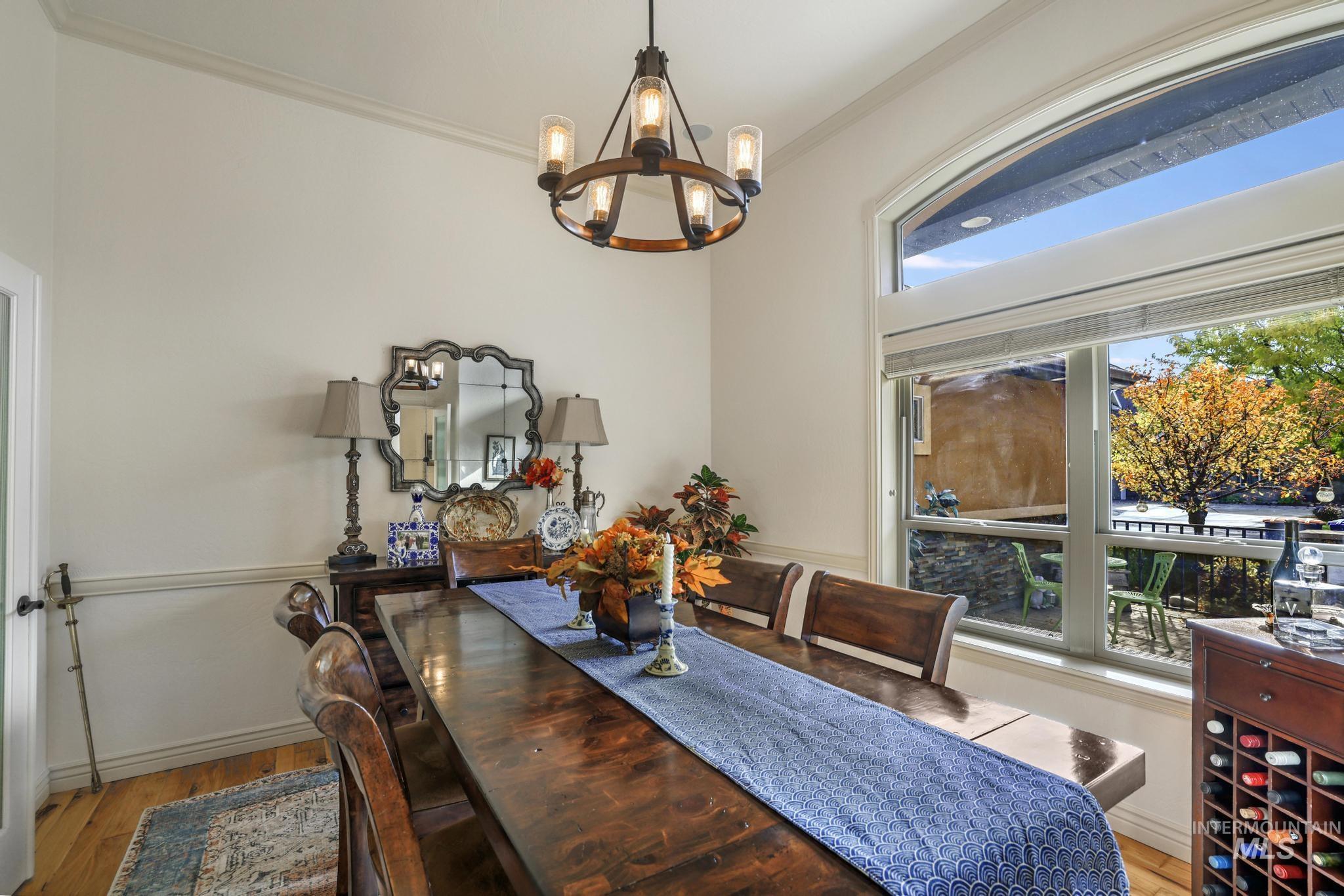 Dining room featuring light wood finished floors, ornamental molding, and a chandelier