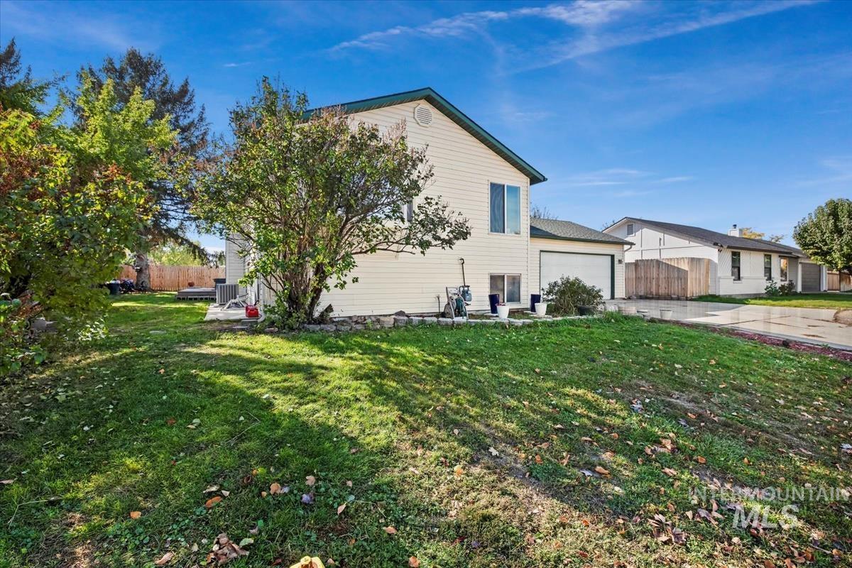 View of side of property featuring a patio, concrete driveway, and an attached garage