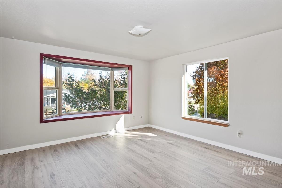 Empty room featuring light wood-type flooring and healthy amount of natural light
