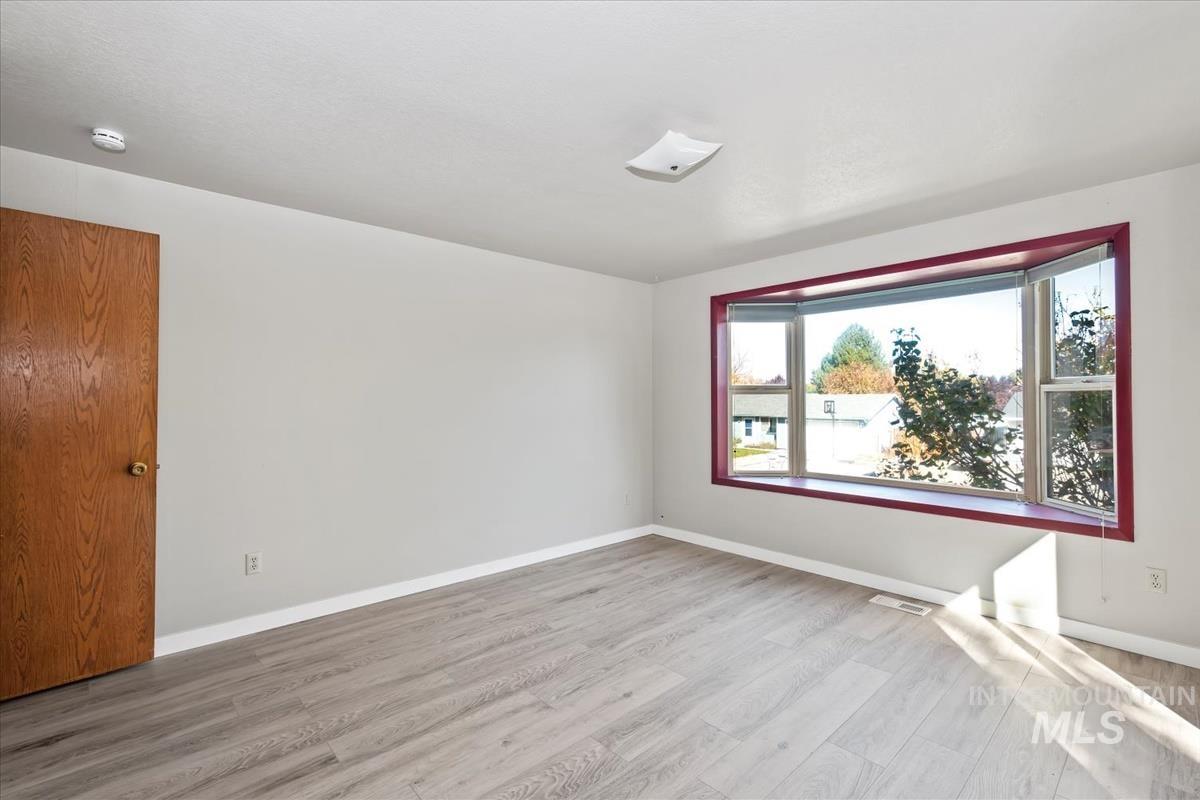 Spare room featuring light wood finished floors and baseboards