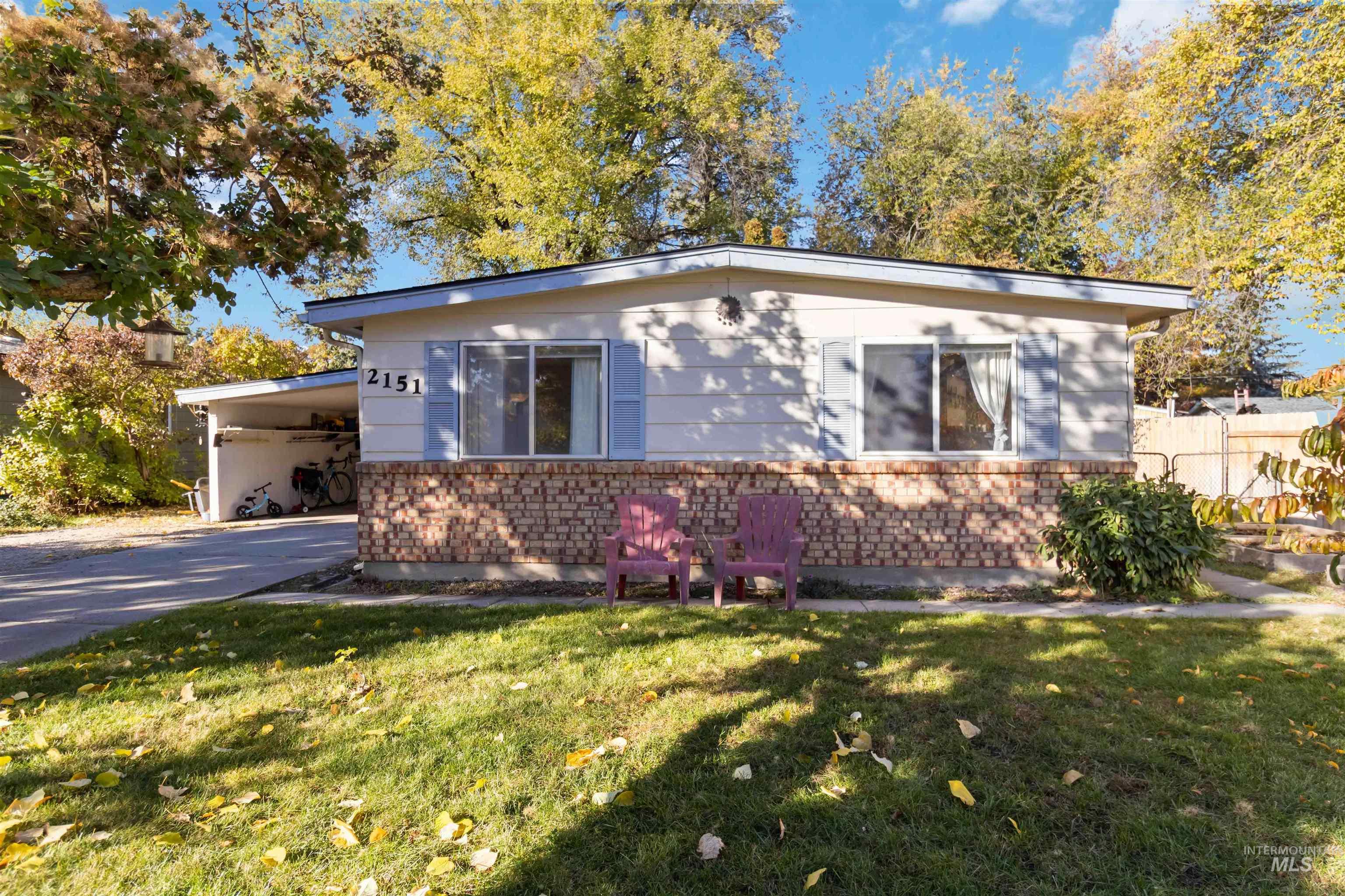 View of front of property featuring a front yard, concrete driveway, and an attached carport