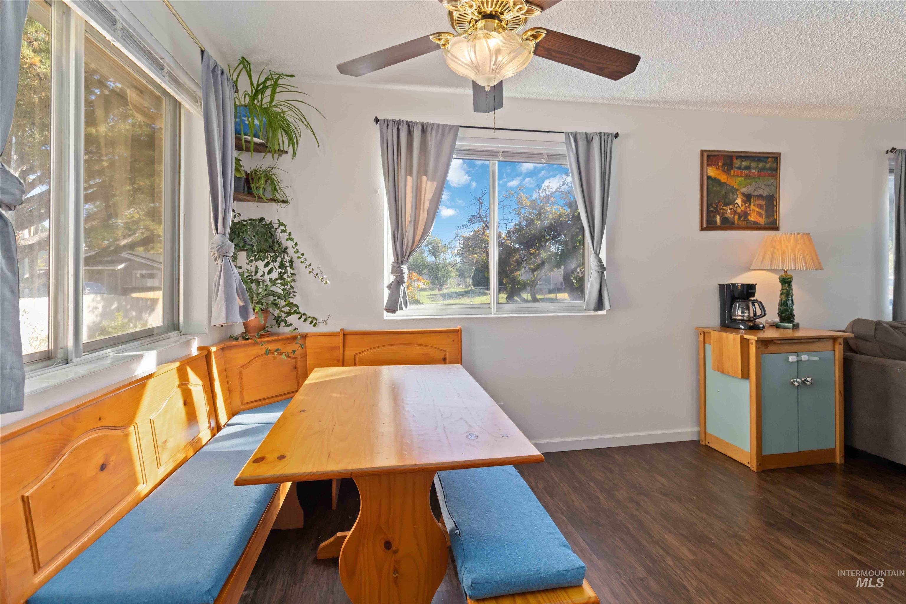 Unfurnished dining area with wood finished floors and a textured ceiling
