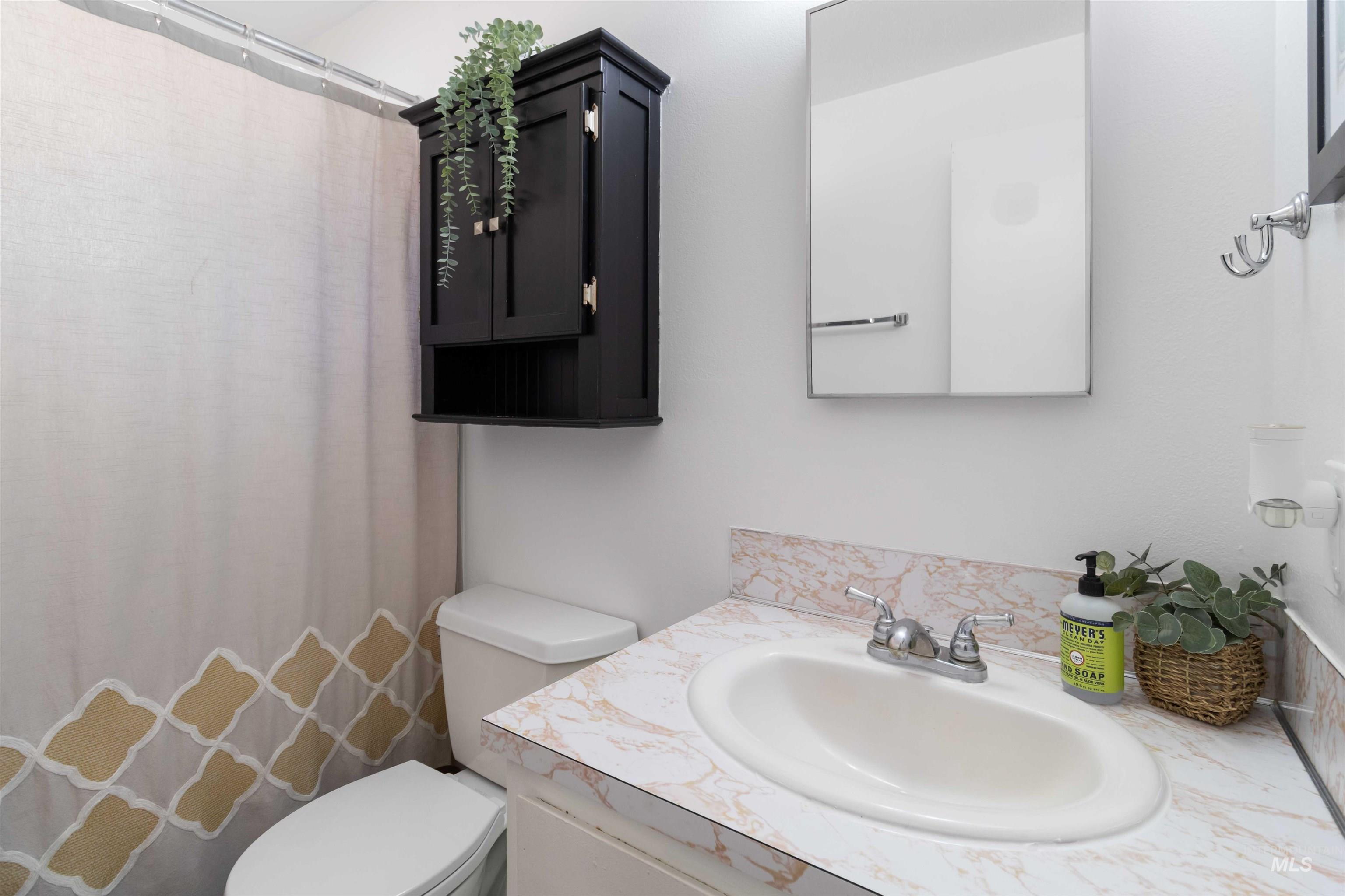 Bathroom featuring a shower with curtain and vanity