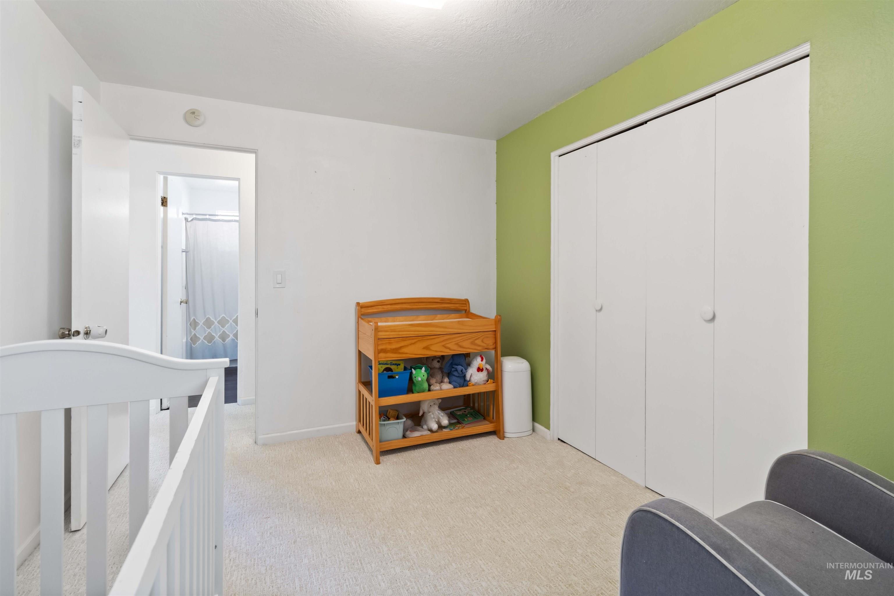Bedroom with light carpet and a closet