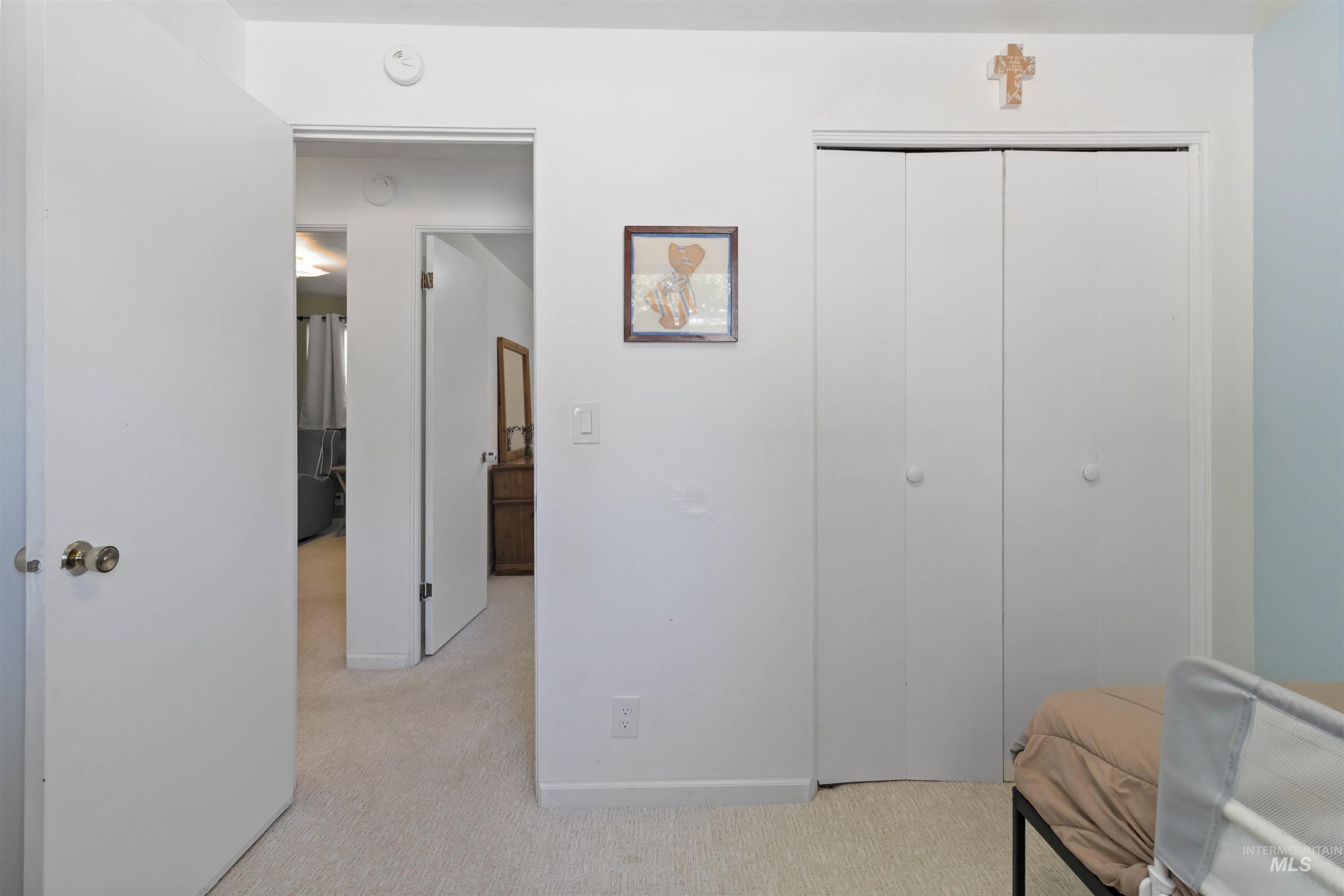 Bedroom featuring light carpet and a closet