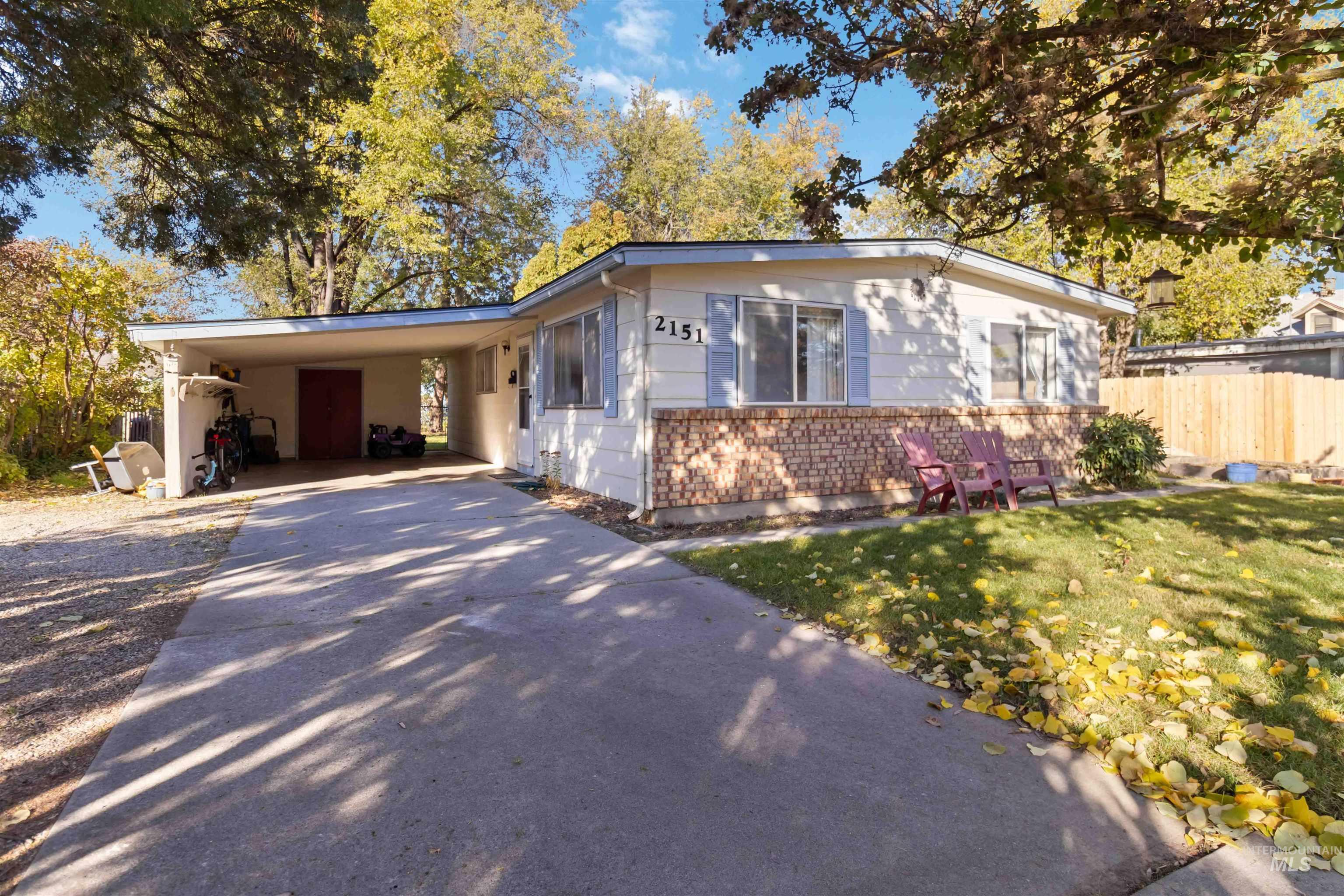 View of front facade with a carport, concrete driveway, and brick siding