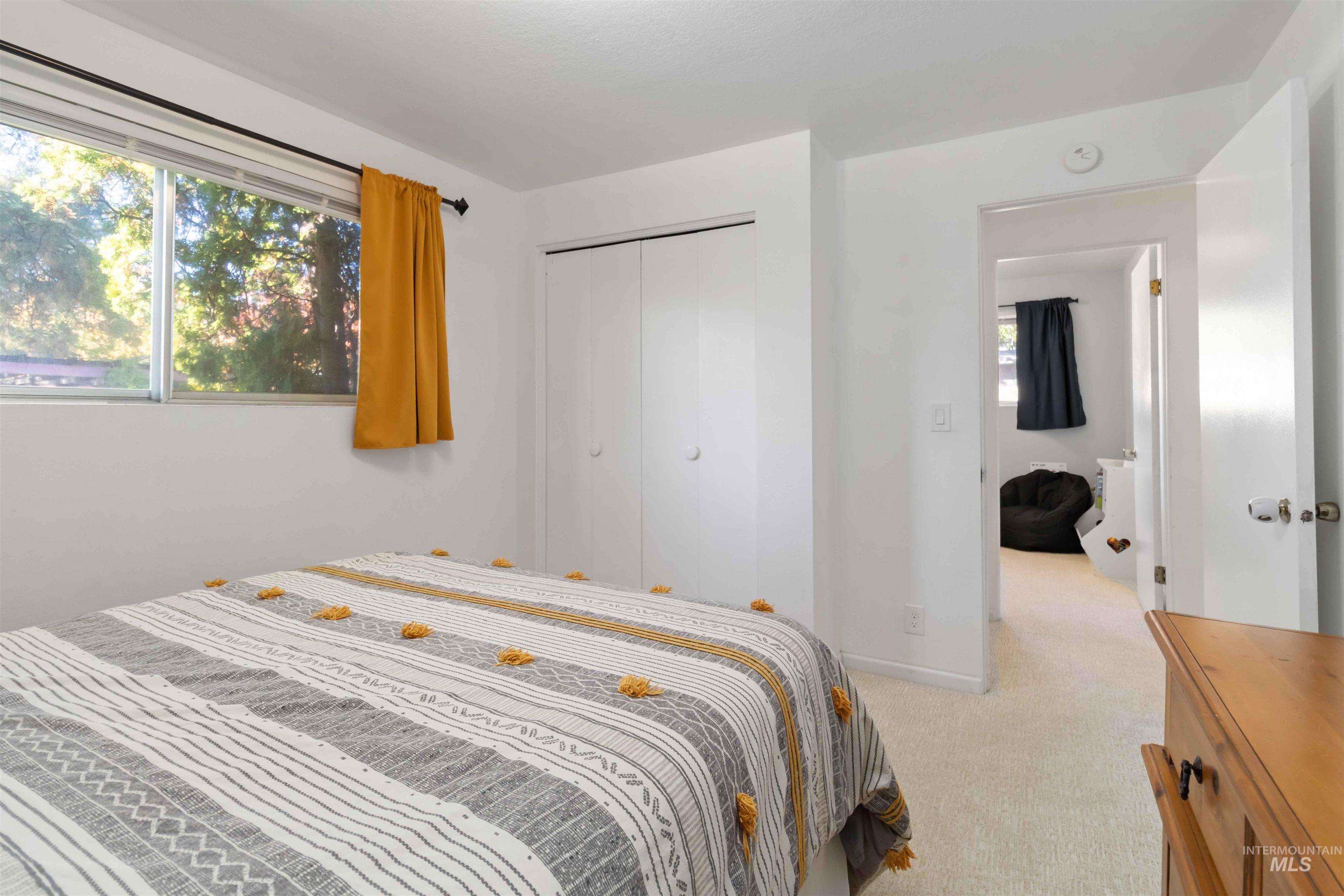Bedroom featuring light colored carpet and a closet