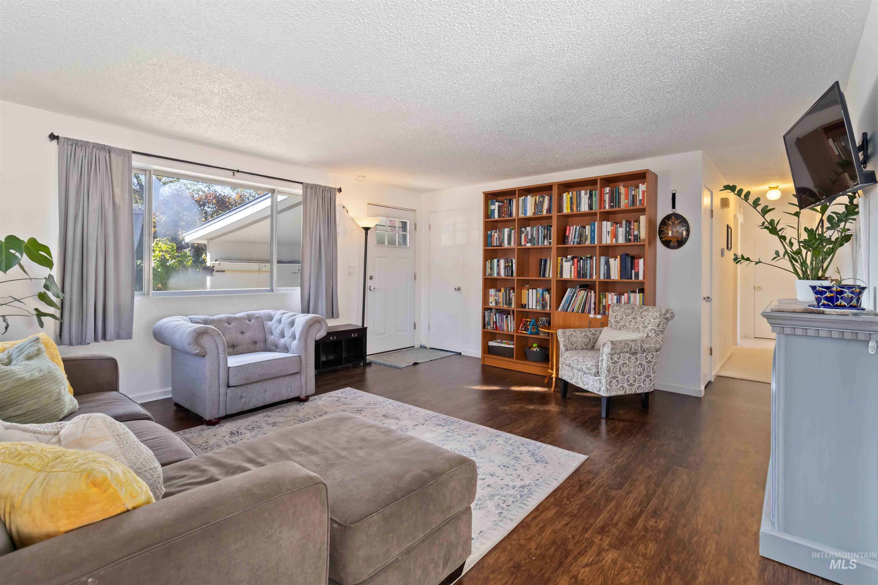 Living area with dark wood-style flooring and a textured ceiling