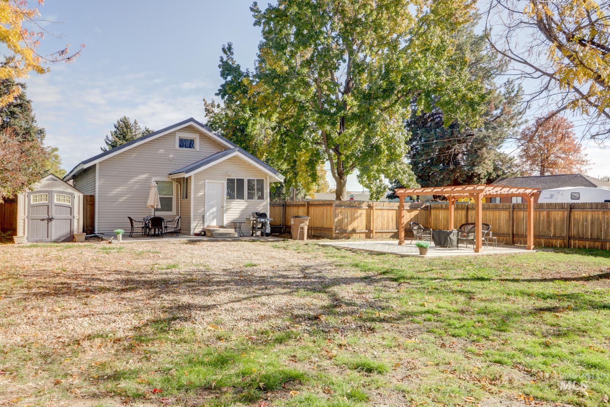 Rear view of property featuring a patio area, a storage shed, a fenced backyard, and a pergola