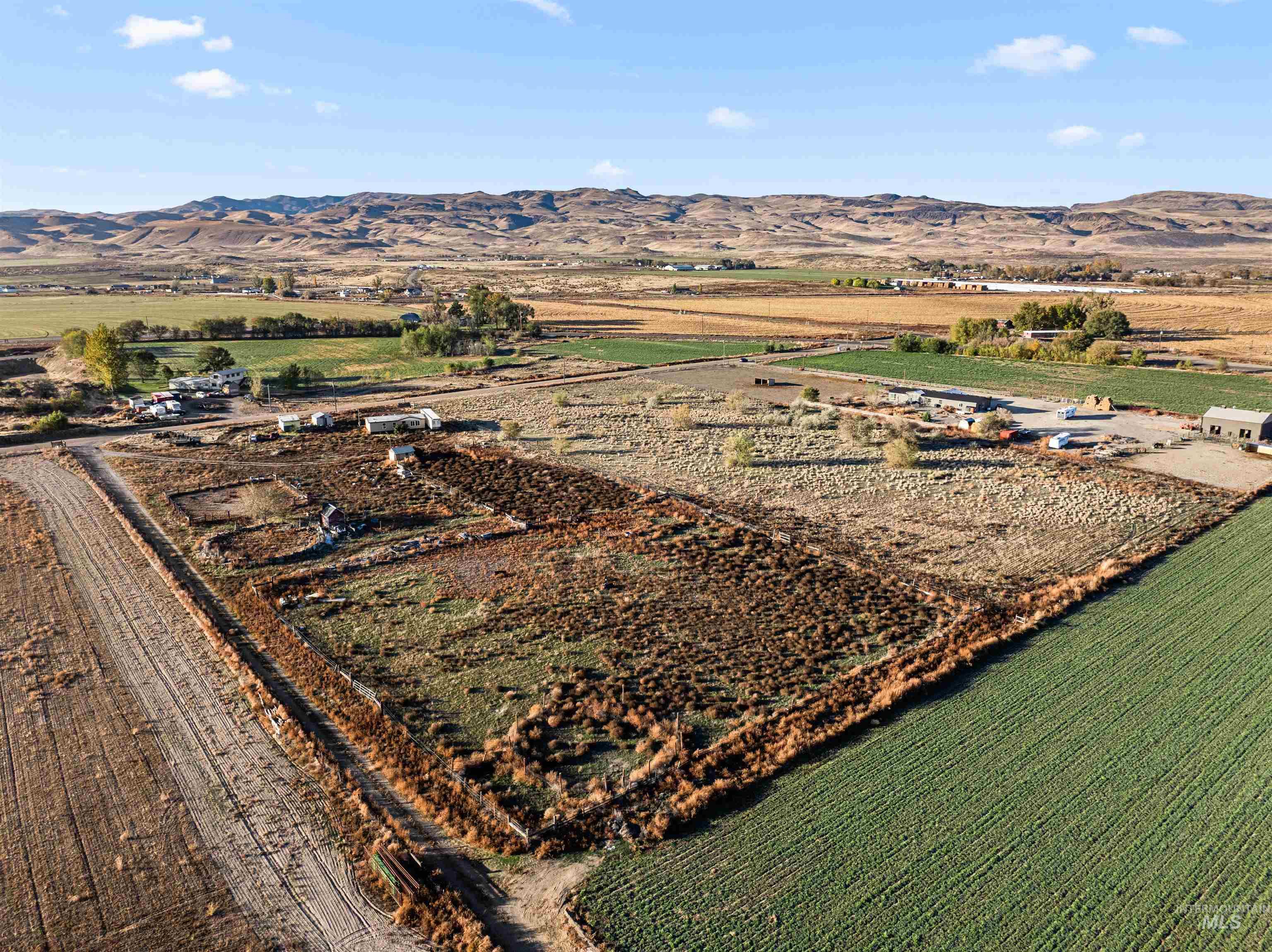 Aerial overview of property's location with rural landscape and a mountainous background