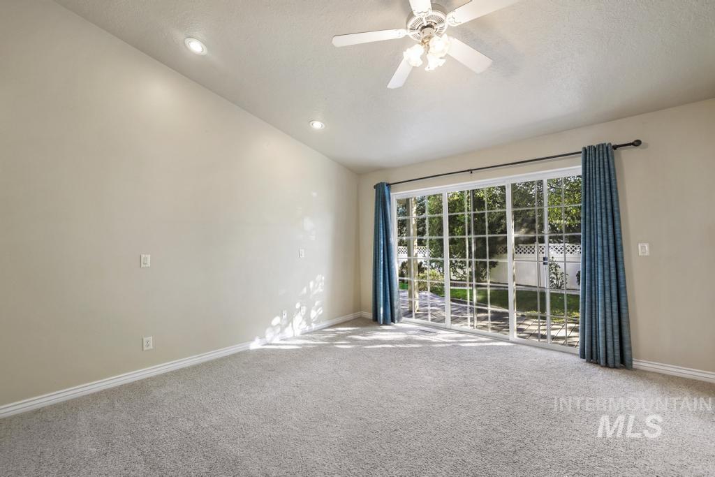 Carpeted spare room featuring lofted ceiling, ceiling fan, recessed lighting, and a textured ceiling