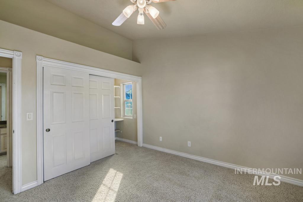 Unfurnished bedroom with light colored carpet, a closet, and ceiling fan