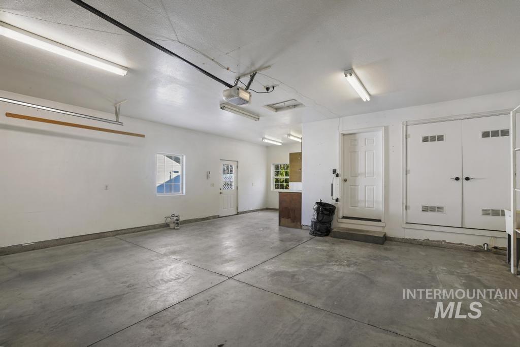 Garage featuring baseboards and a garage door opener
