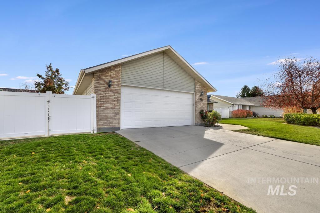 View of side of property featuring brick siding, driveway, and an attached garage