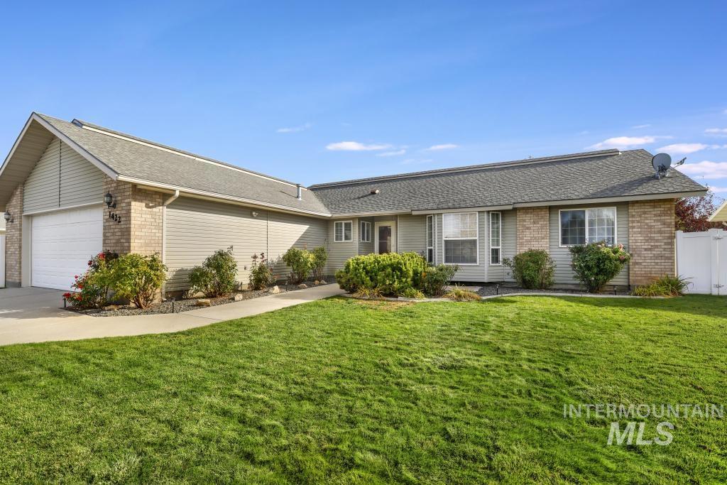 Ranch-style house with brick siding, a shingled roof, an attached garage, and driveway