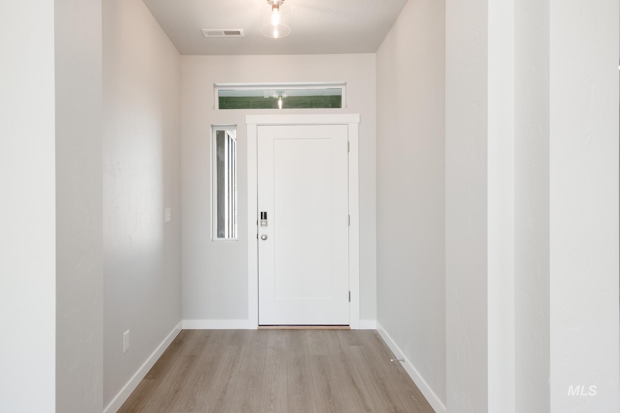 Foyer entrance featuring light wood-style flooring and baseboards