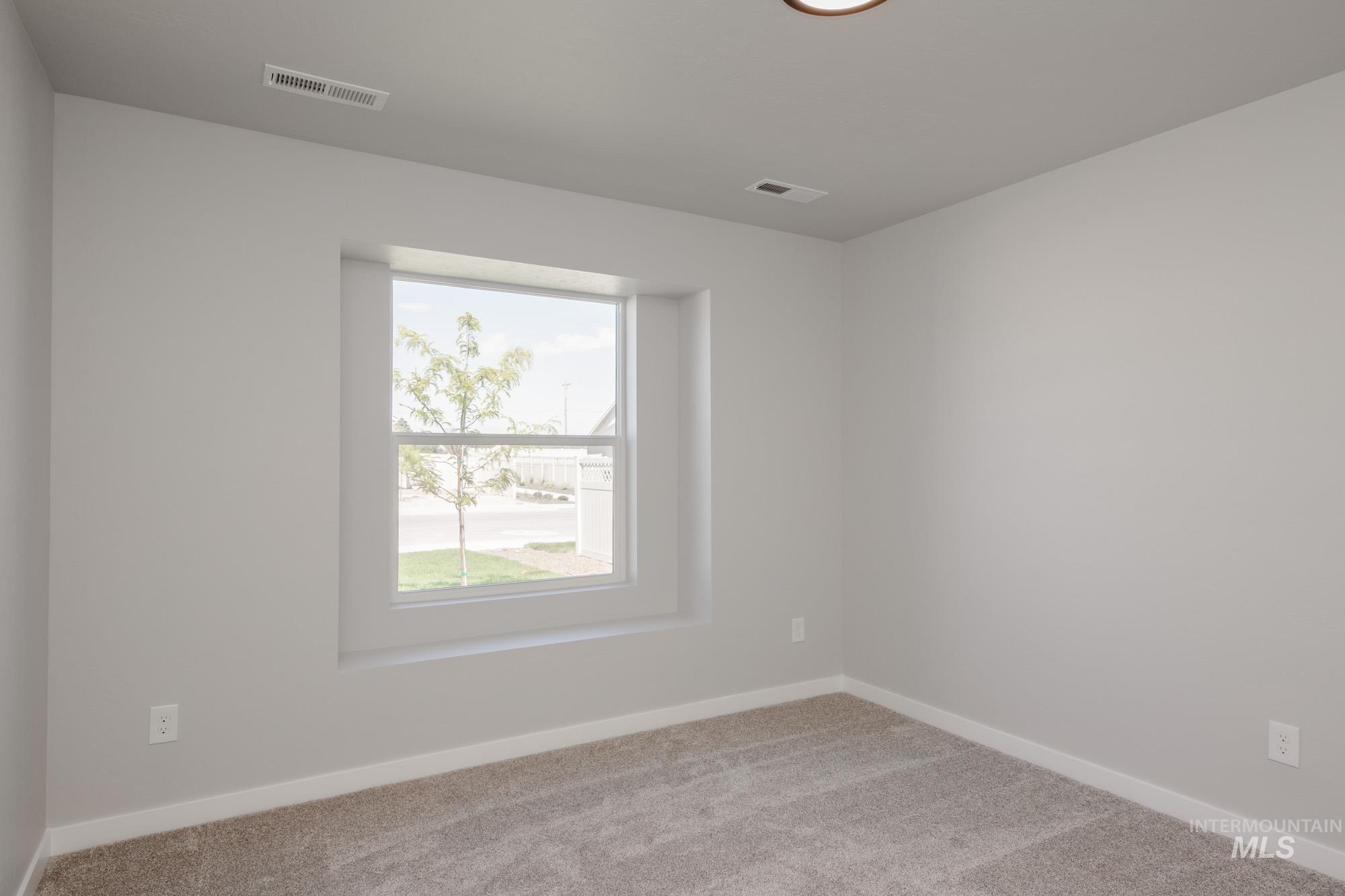 Carpeted spare room with baseboards