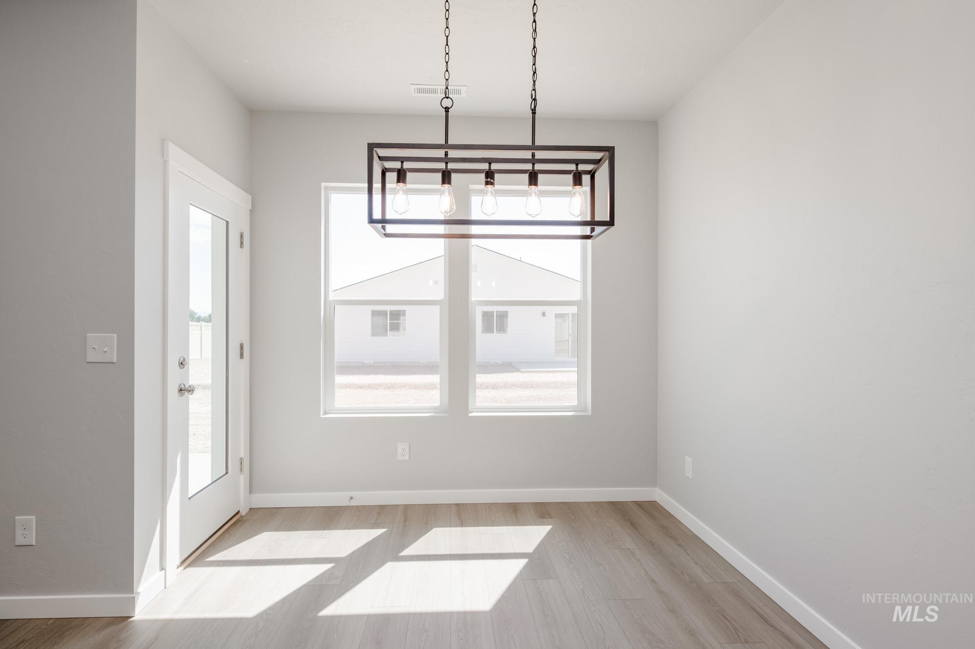 Unfurnished dining area featuring baseboards and light wood-style floors