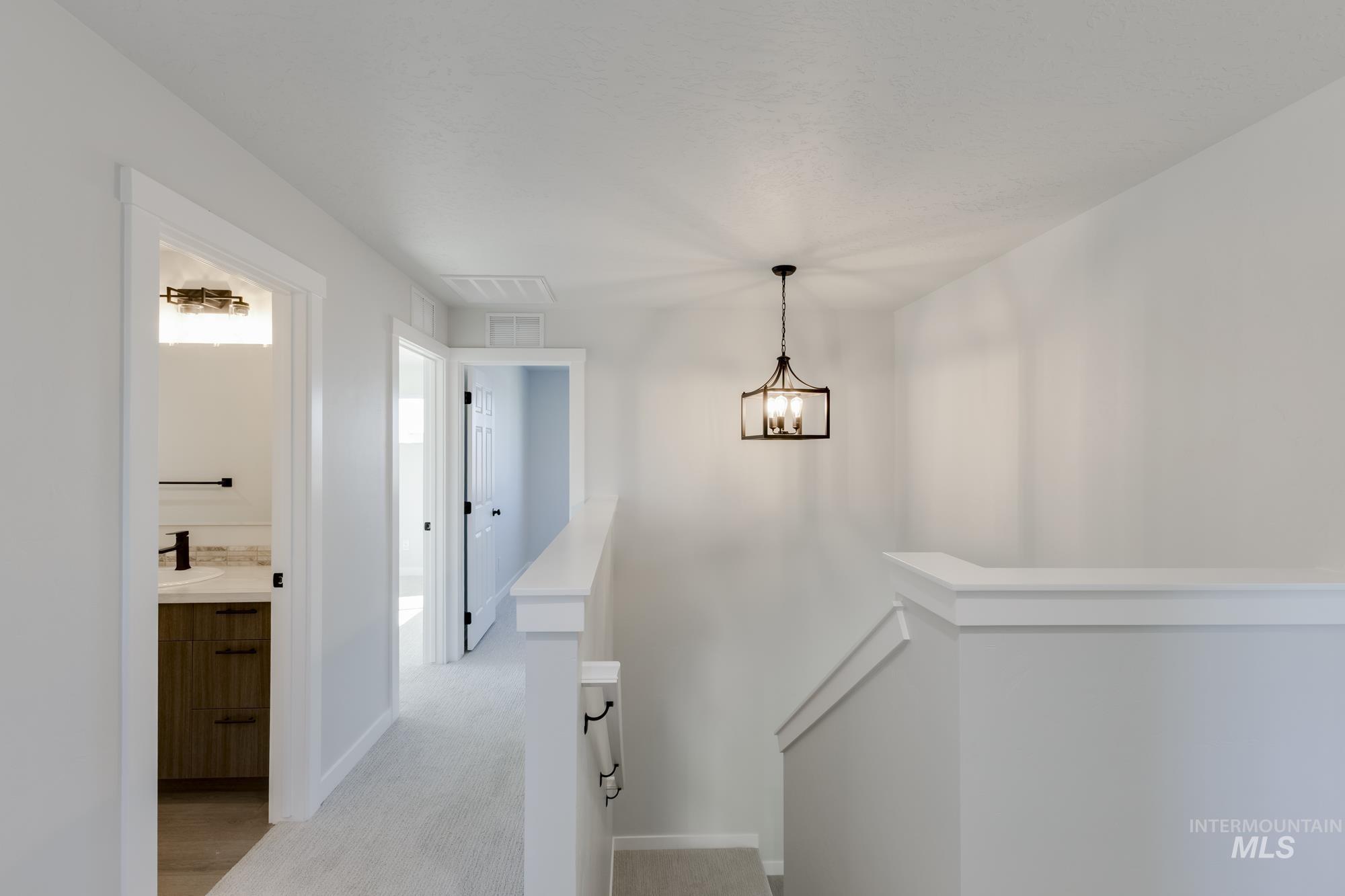 Stairway with carpet flooring and a chandelier