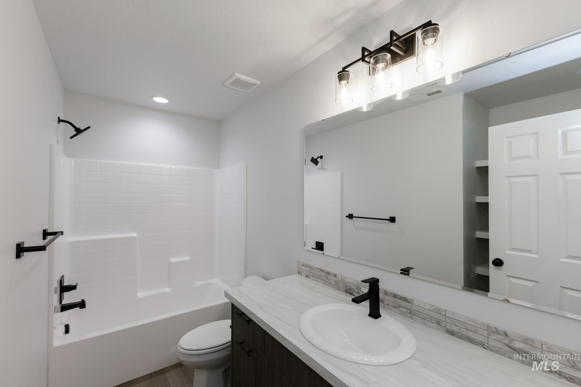Full bath featuring vanity, shower / bathtub combination, and recessed lighting