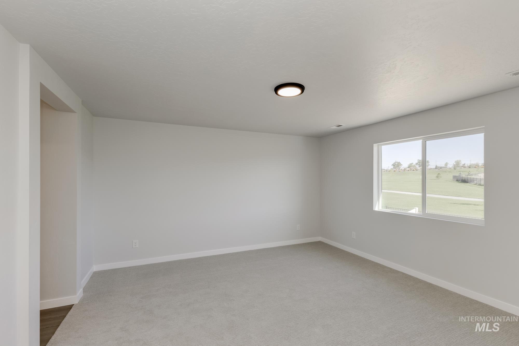 Empty room featuring baseboards and light carpet