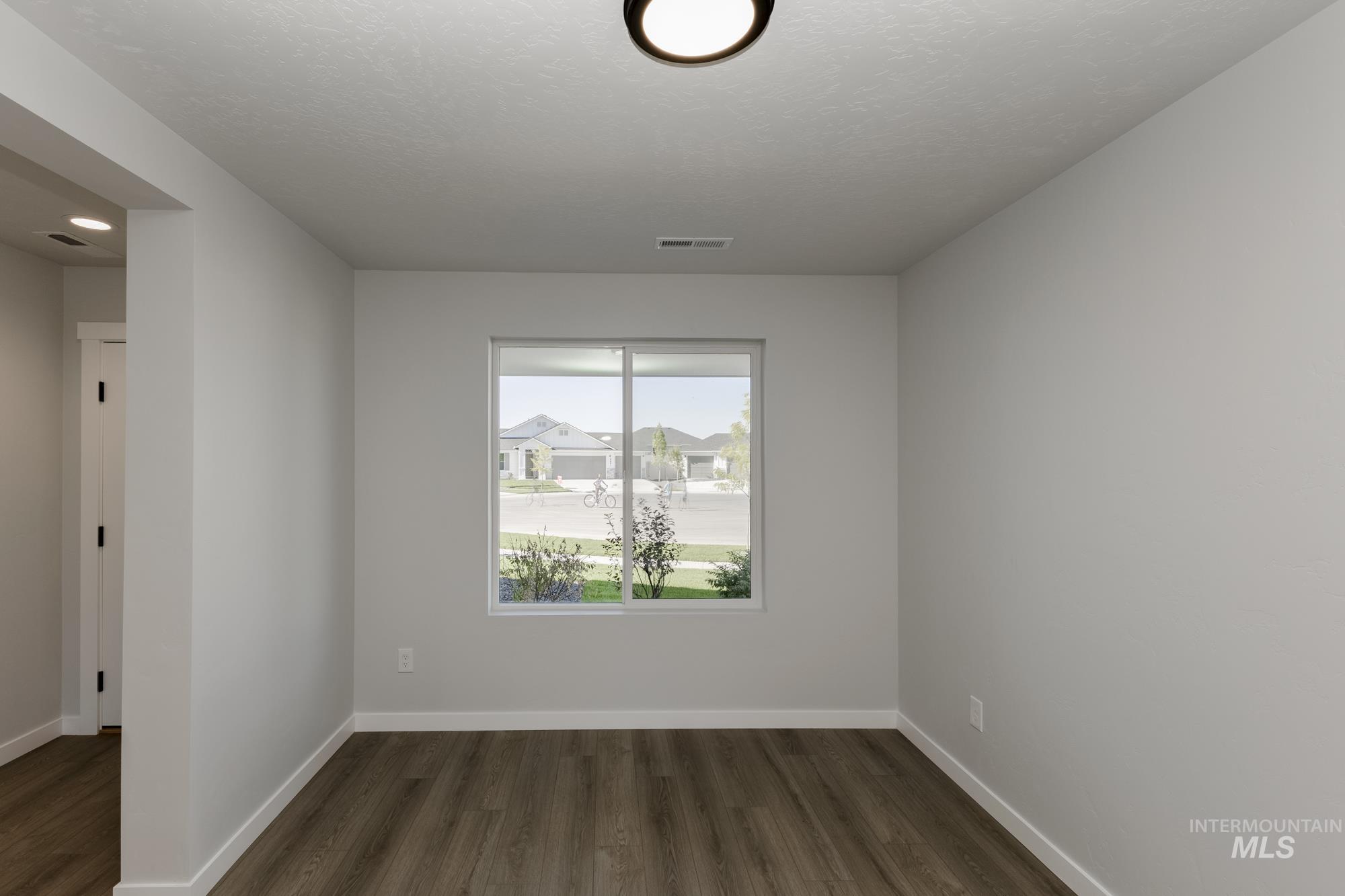 Spare room with dark wood-style flooring and a textured ceiling