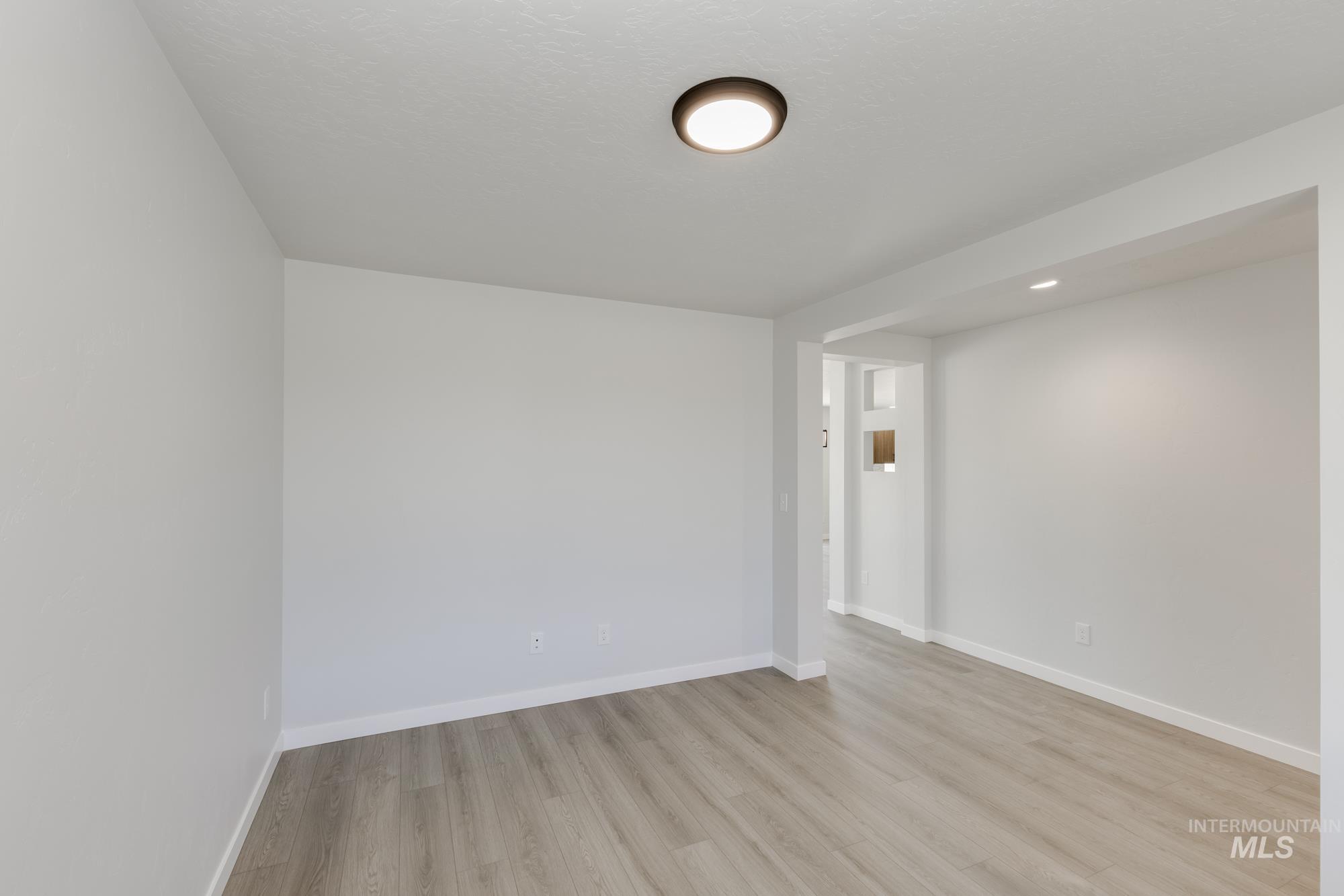 Unfurnished room with light wood-type flooring and recessed lighting