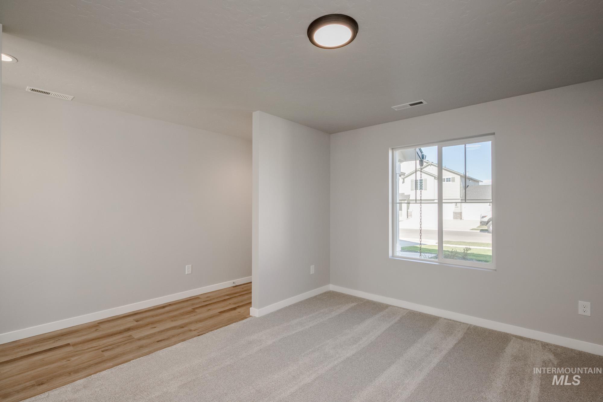 Empty room featuring baseboards and light carpet