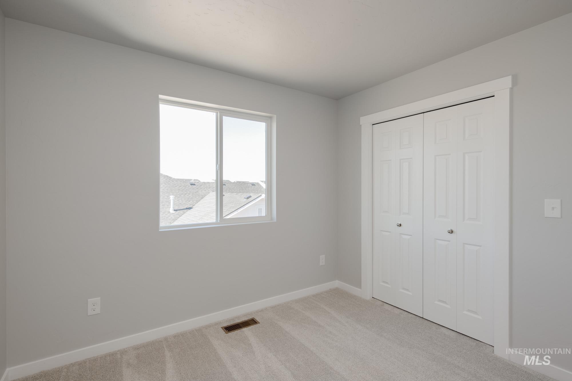 Unfurnished bedroom featuring light colored carpet and a closet