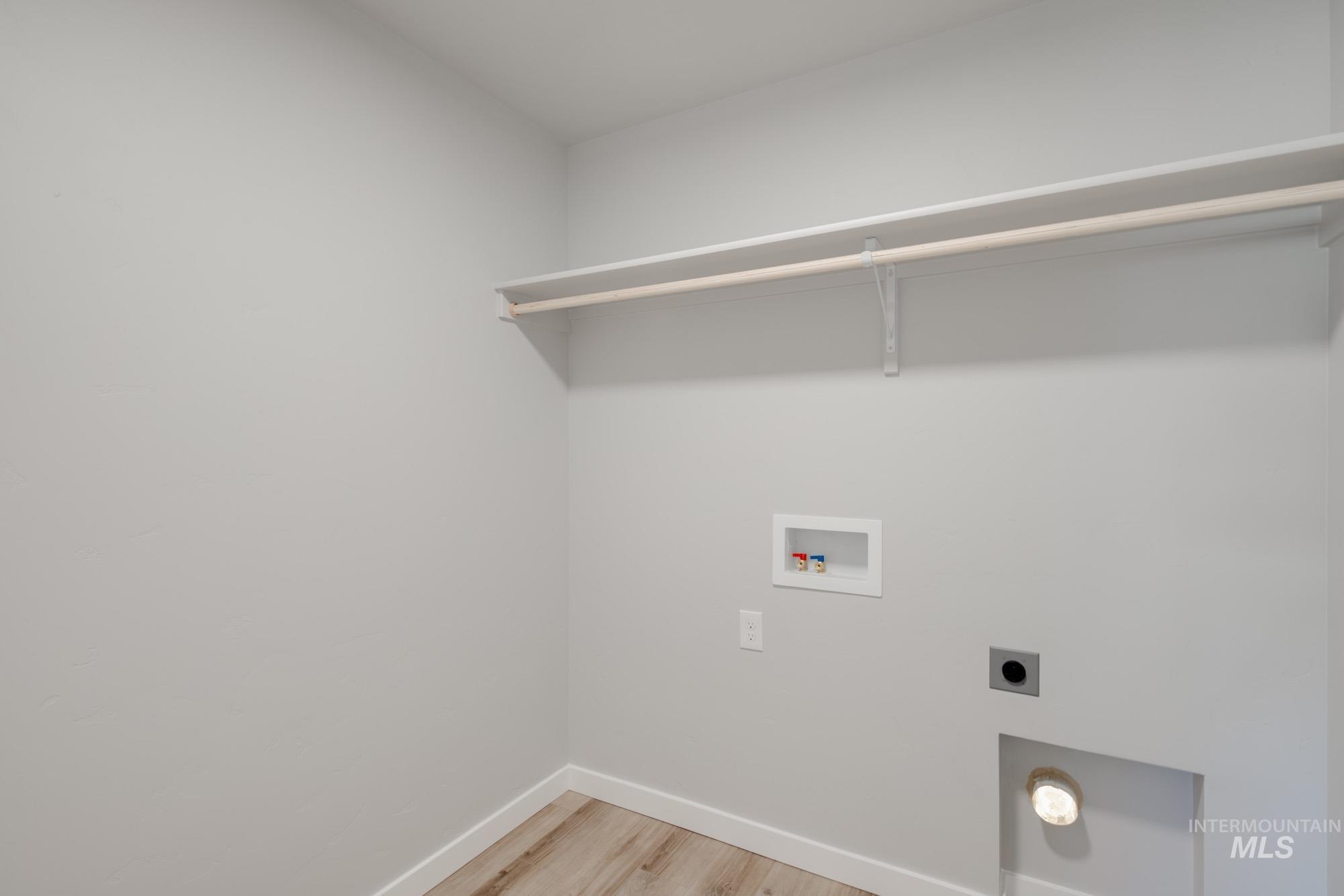 Laundry area featuring light wood-type flooring, hookup for an electric dryer, and washer hookup