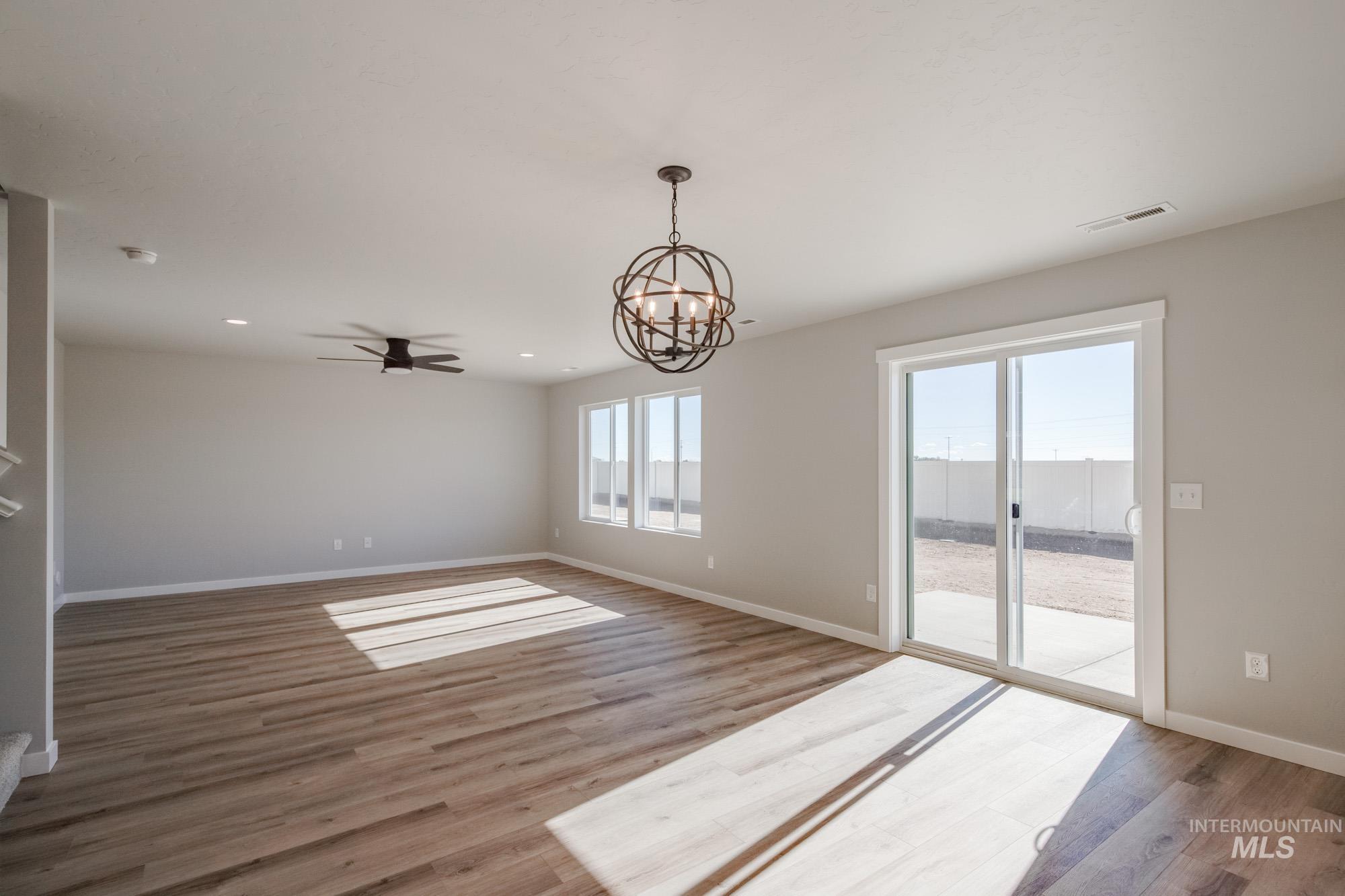 Unfurnished room with a chandelier, a ceiling fan, light wood-type flooring, and recessed lighting