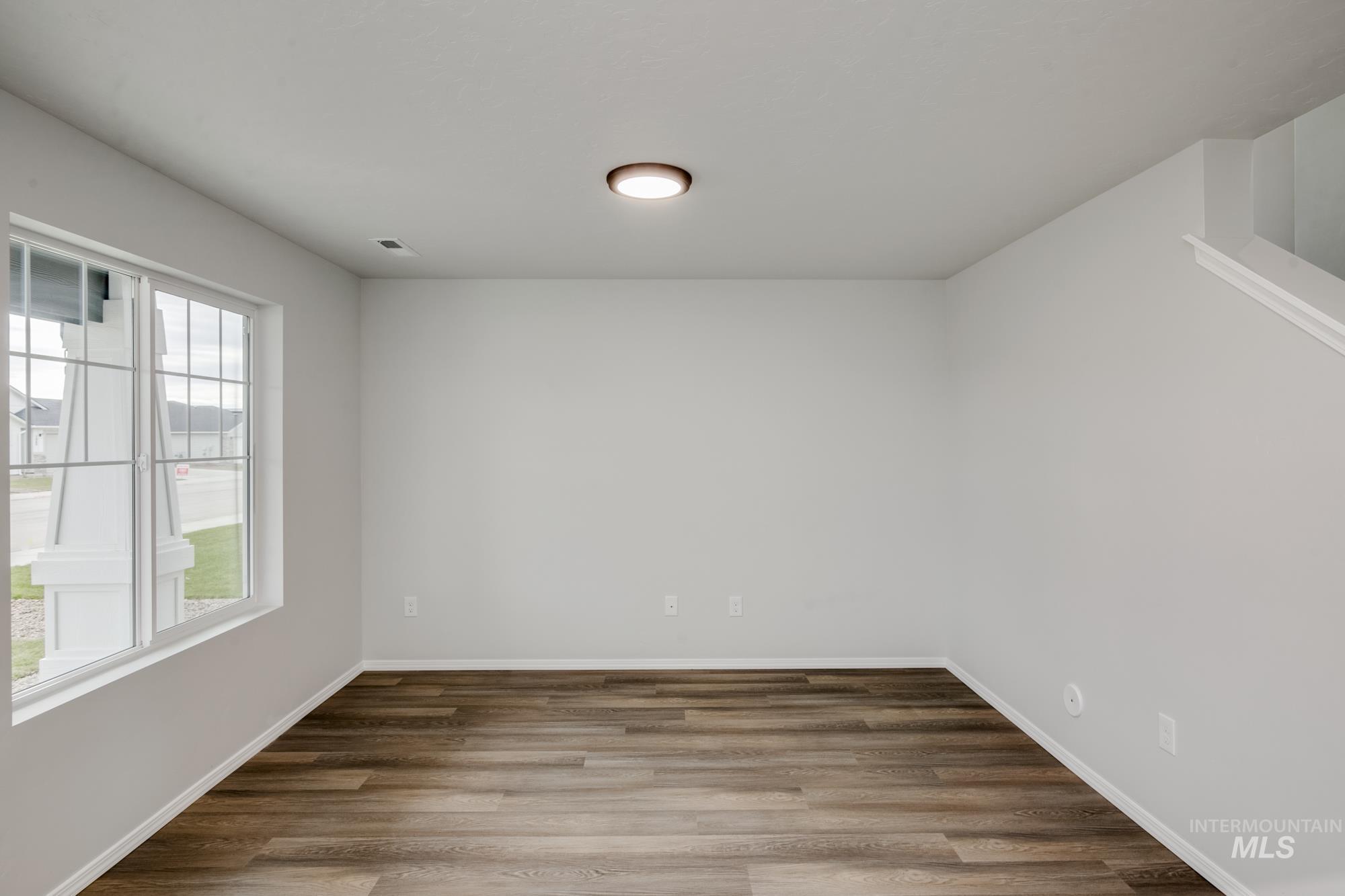 Unfurnished room with wood finished floors and baseboards