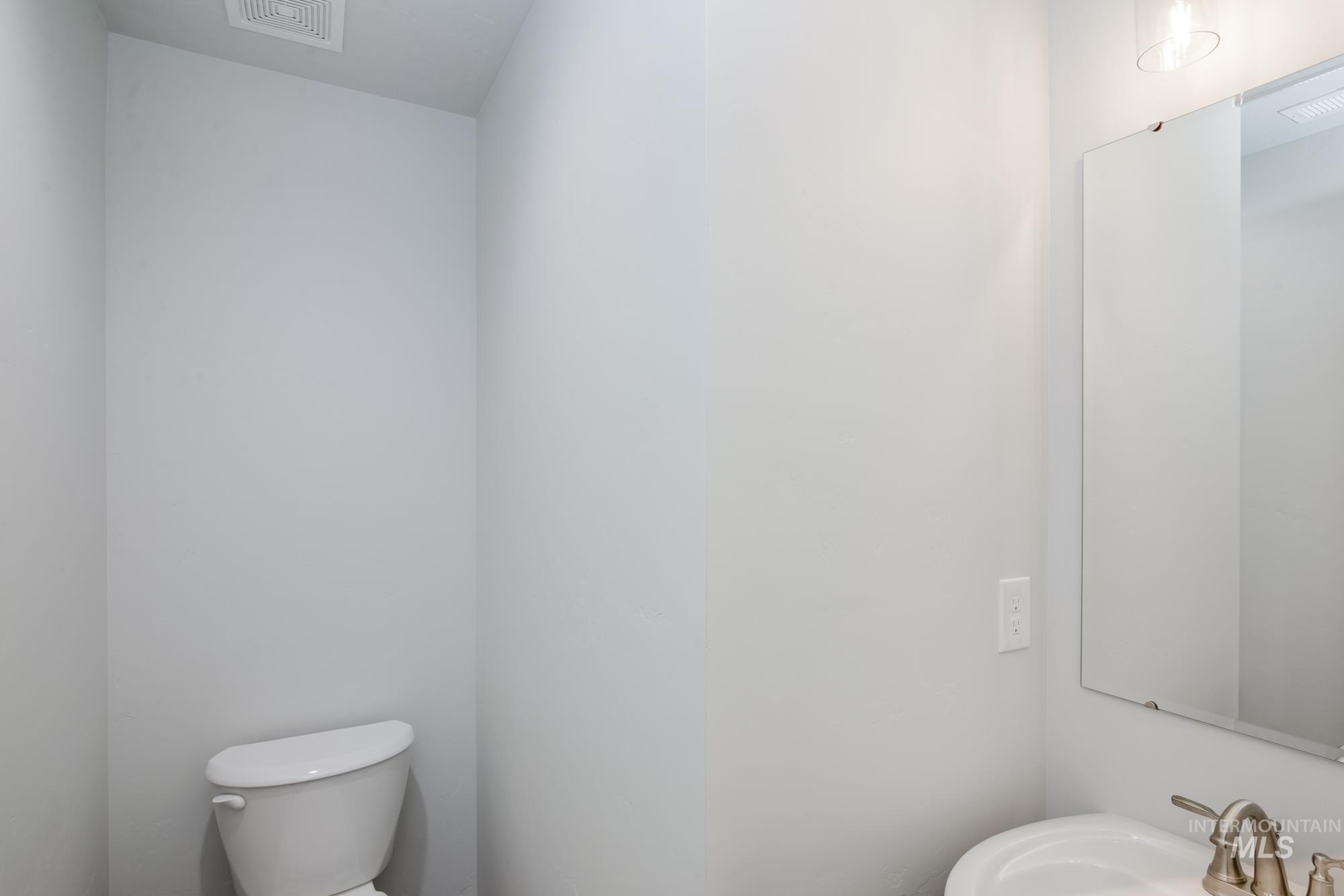 Half bath featuring toilet and a sink