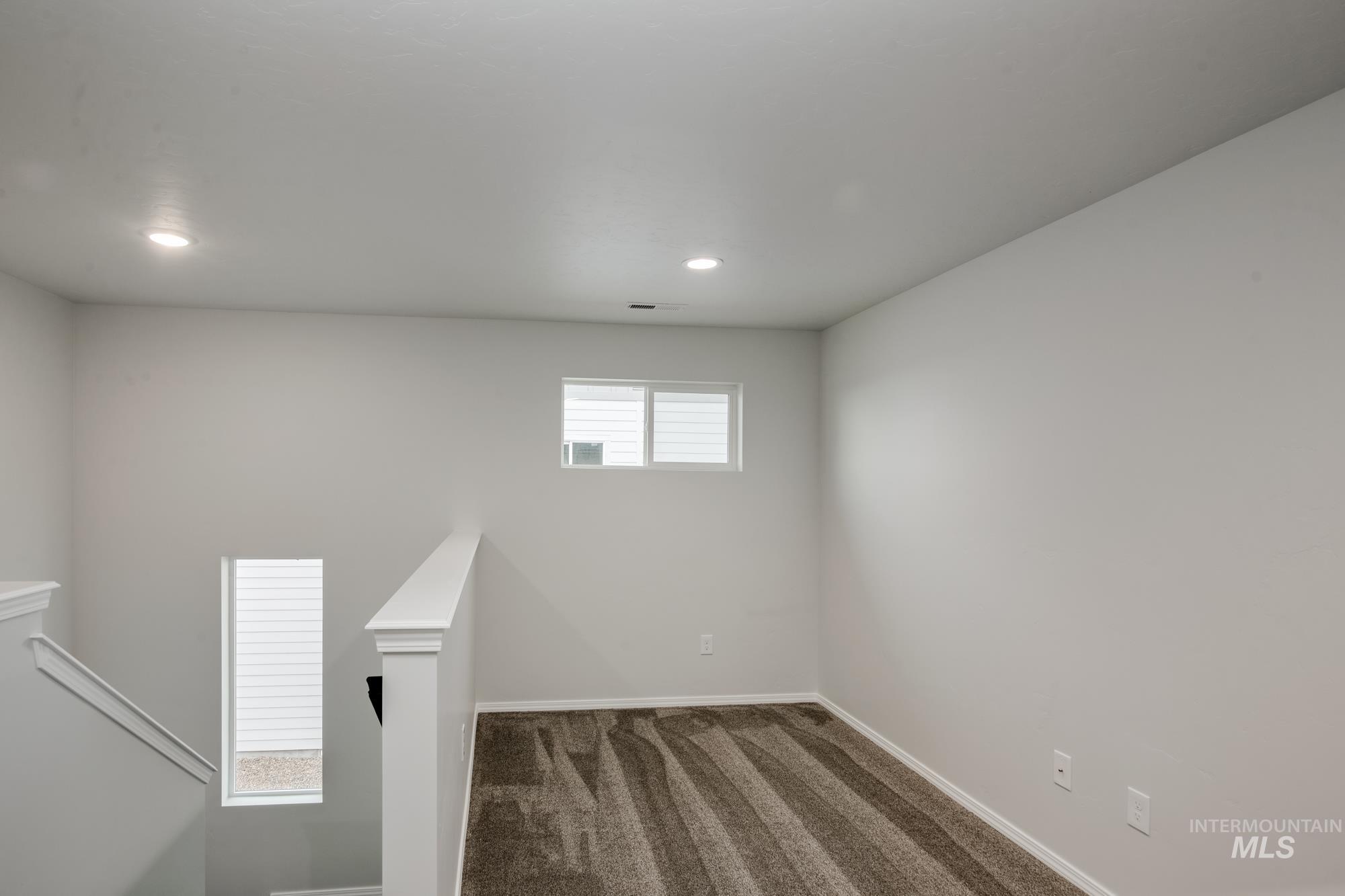 Carpeted spare room featuring baseboards and recessed lighting