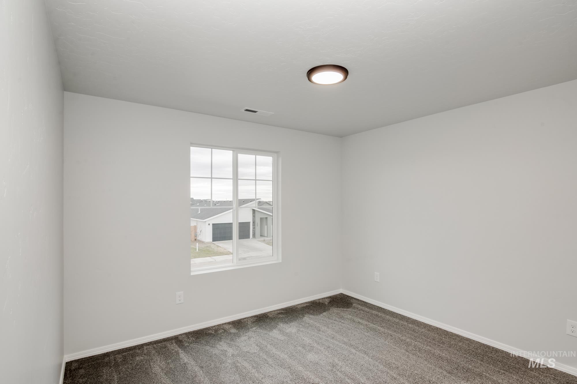 Carpeted empty room featuring baseboards