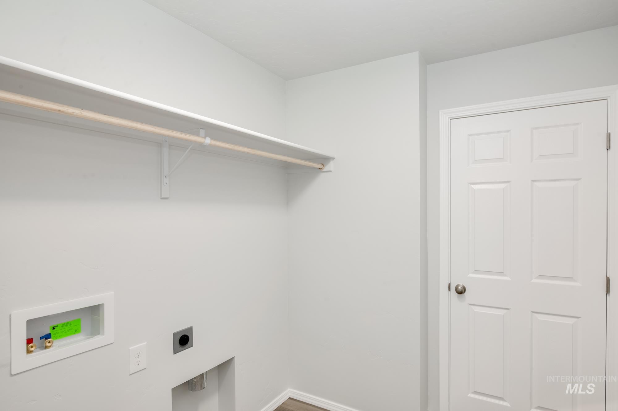 Laundry area featuring hookup for an electric dryer, washer hookup, and wood finished floors
