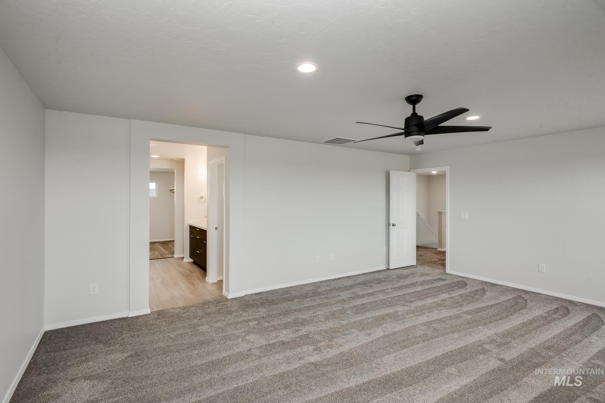 Empty room with light colored carpet, recessed lighting, and ceiling fan