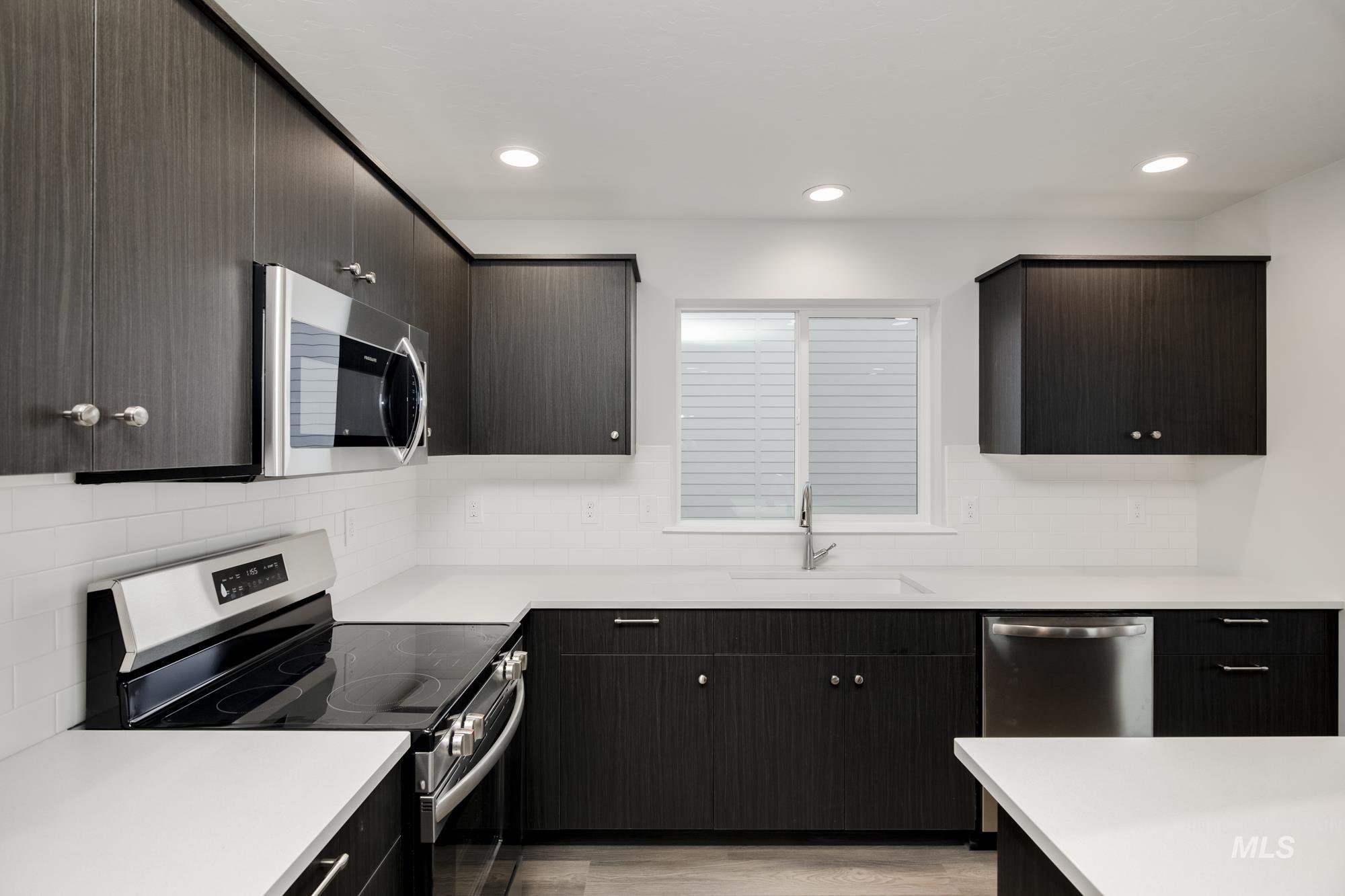 Kitchen with appliances with stainless steel finishes, light wood-type flooring, recessed lighting, backsplash, and modern cabinets