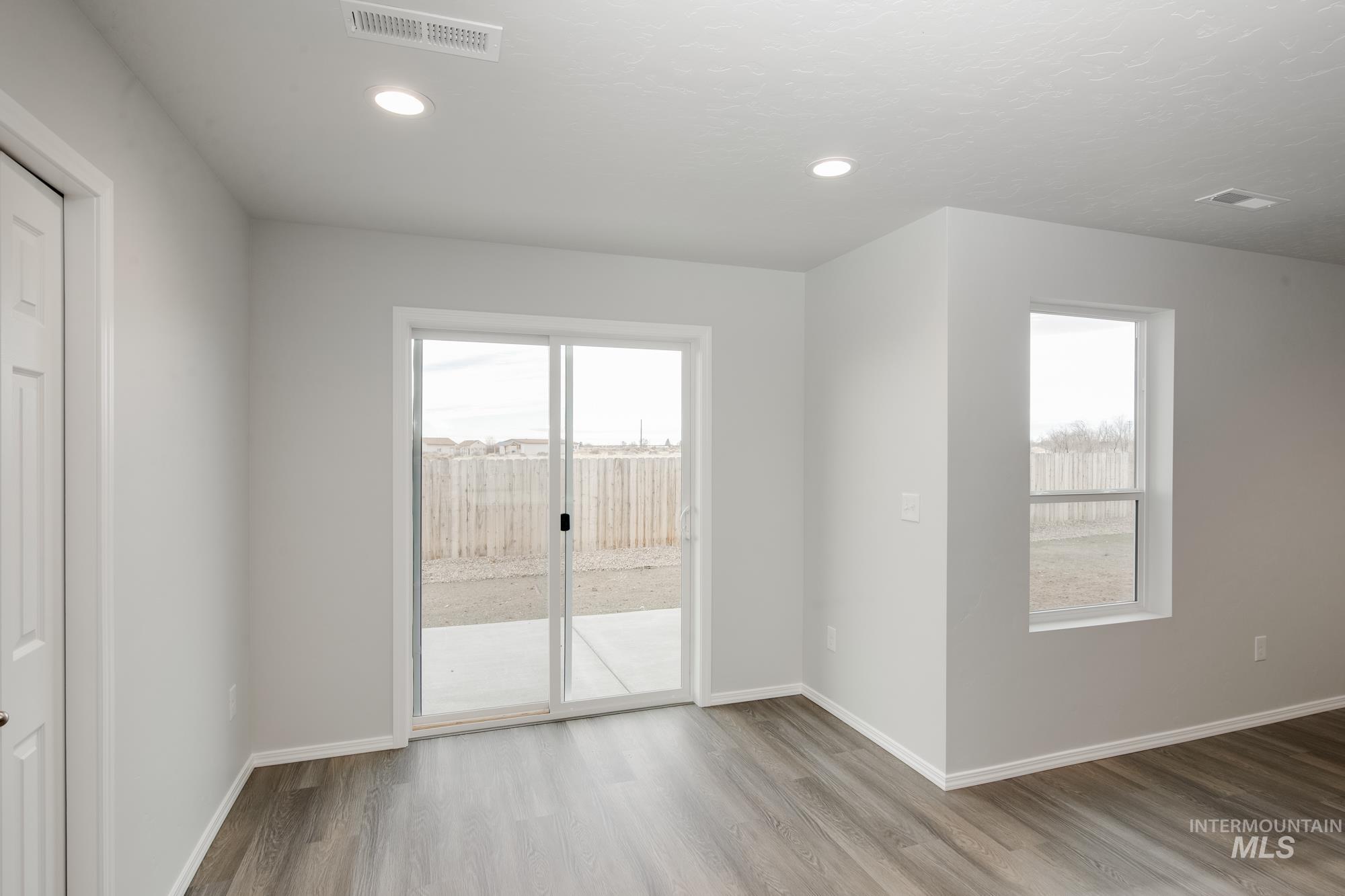 Empty room with wood finished floors, healthy amount of natural light, and recessed lighting