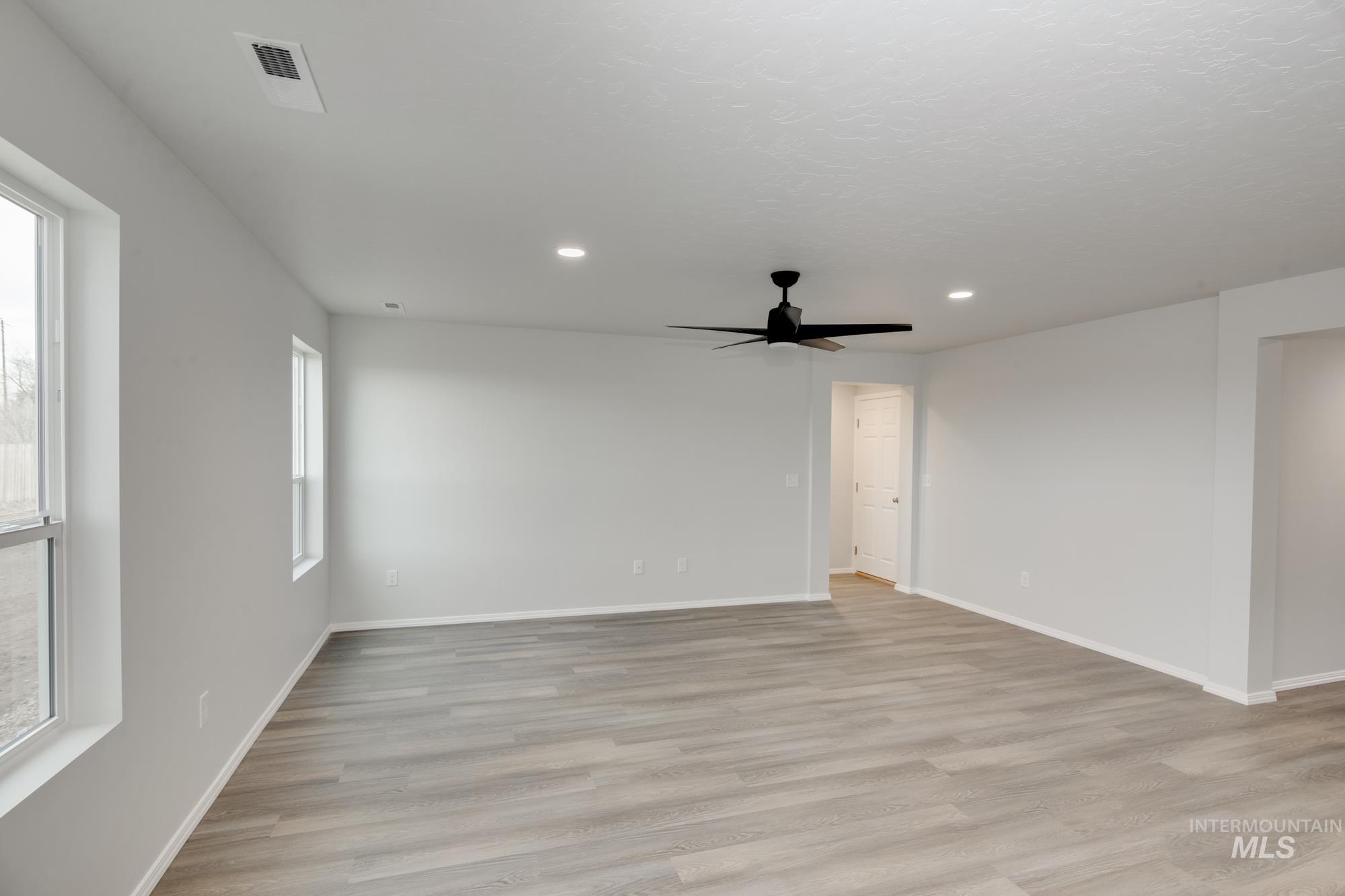 Empty room with light wood finished floors, recessed lighting, and ceiling fan