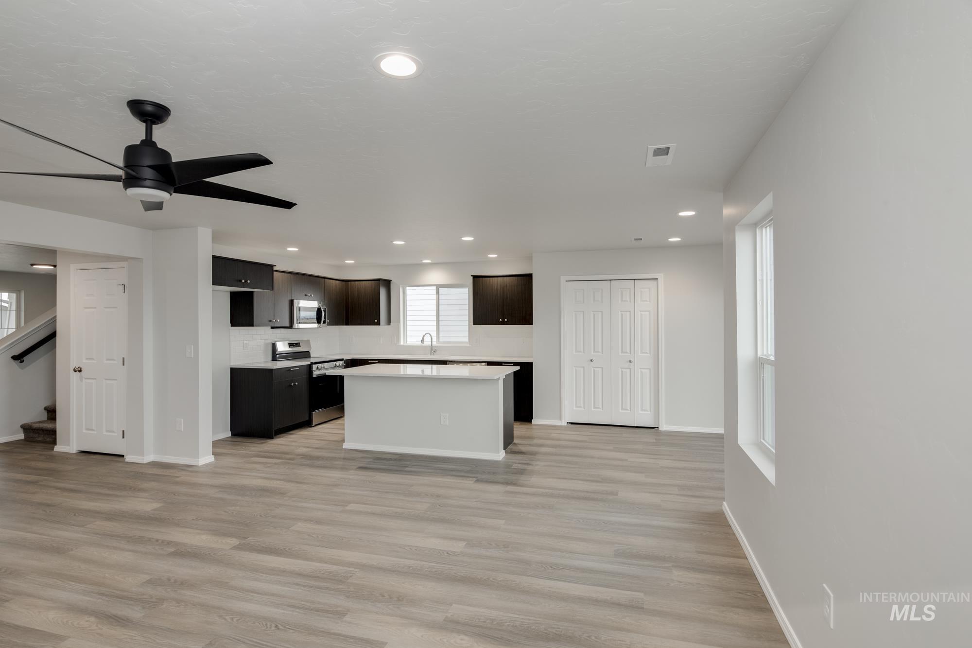 Kitchen featuring a kitchen island, light countertops, recessed lighting, stainless steel appliances, and light wood-style flooring