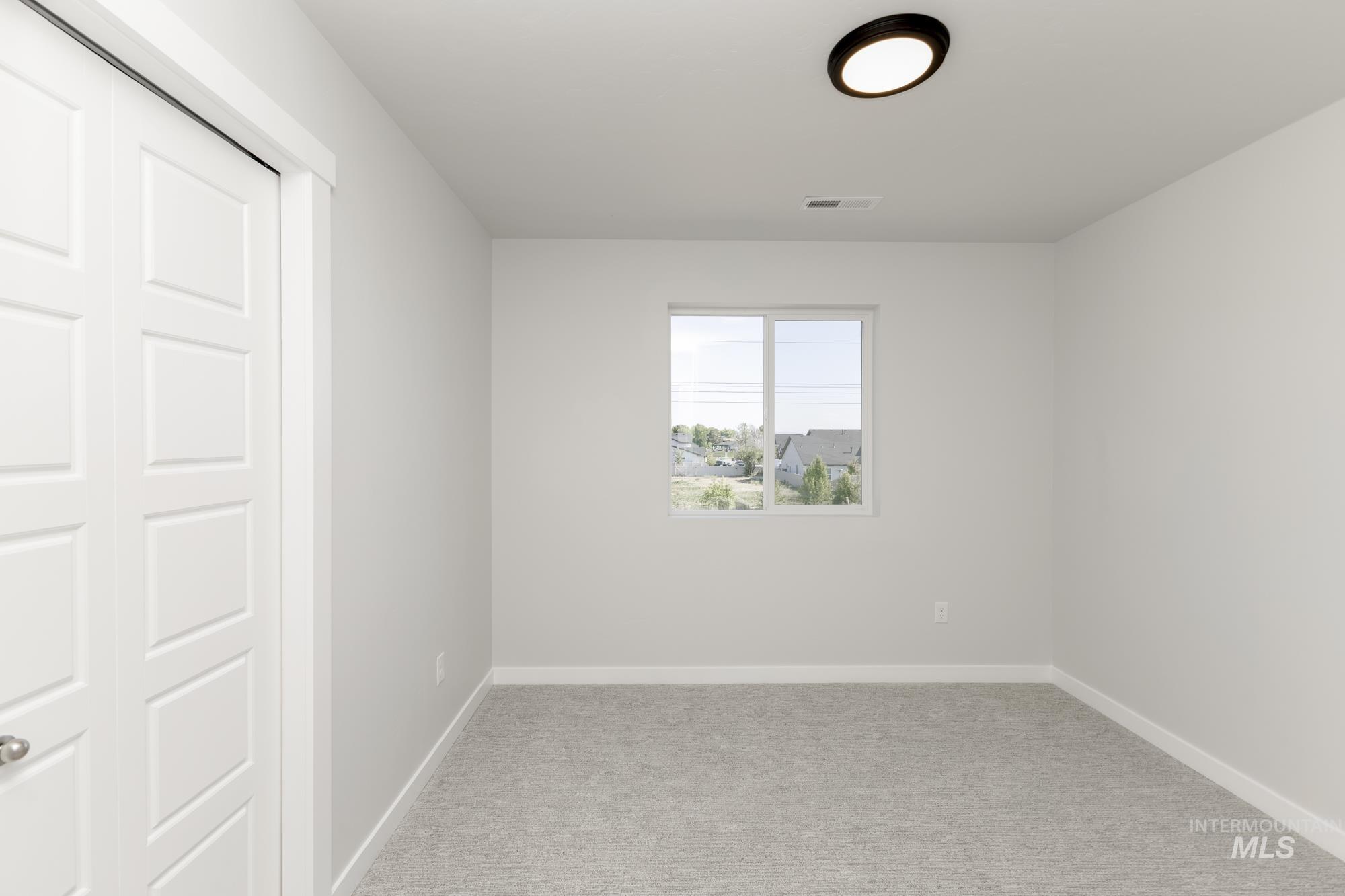 Unfurnished bedroom with light colored carpet and a closet