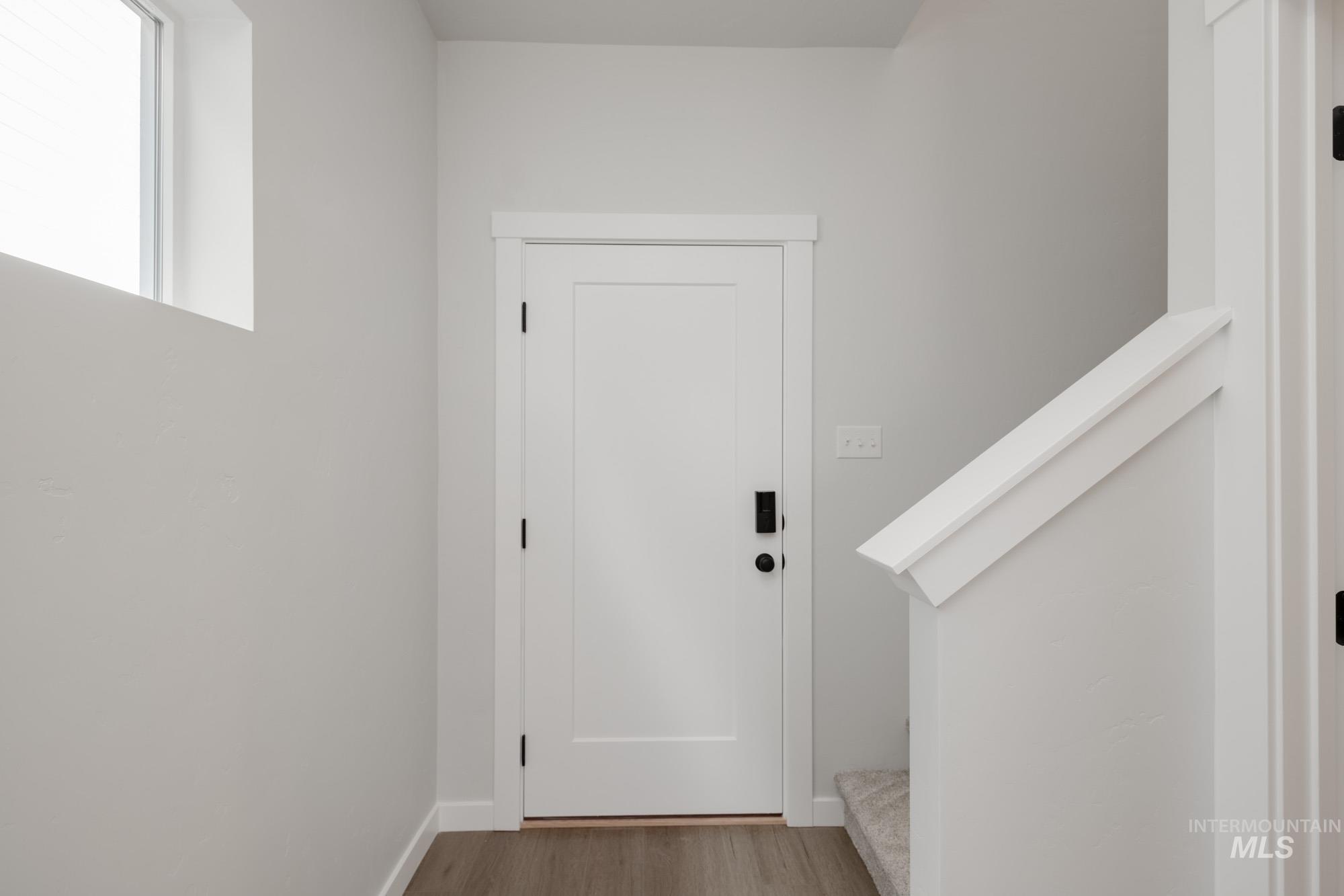 Doorway featuring wood finished floors and stairs