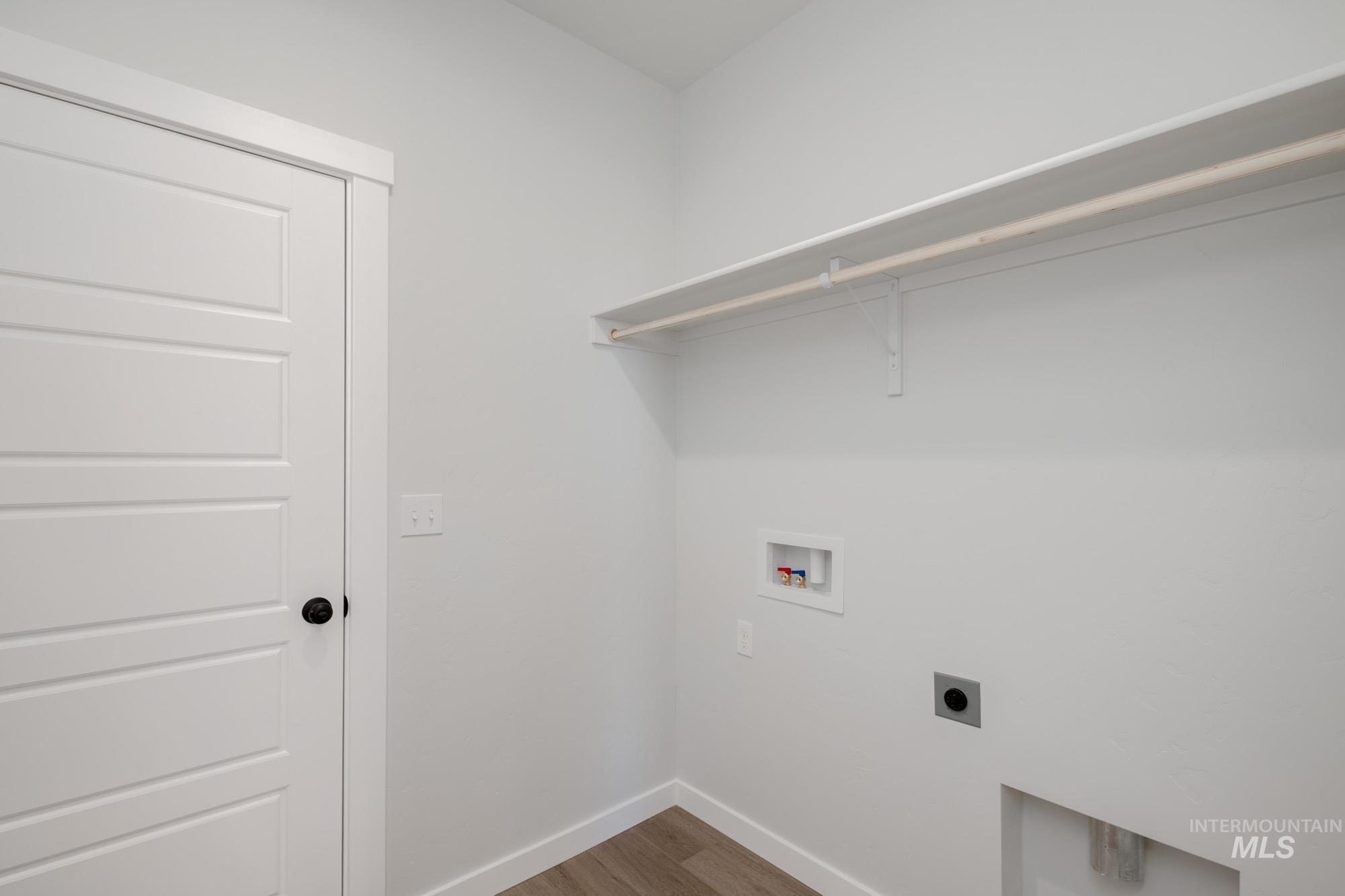 Washroom with light wood finished floors, washer hookup, and hookup for an electric dryer