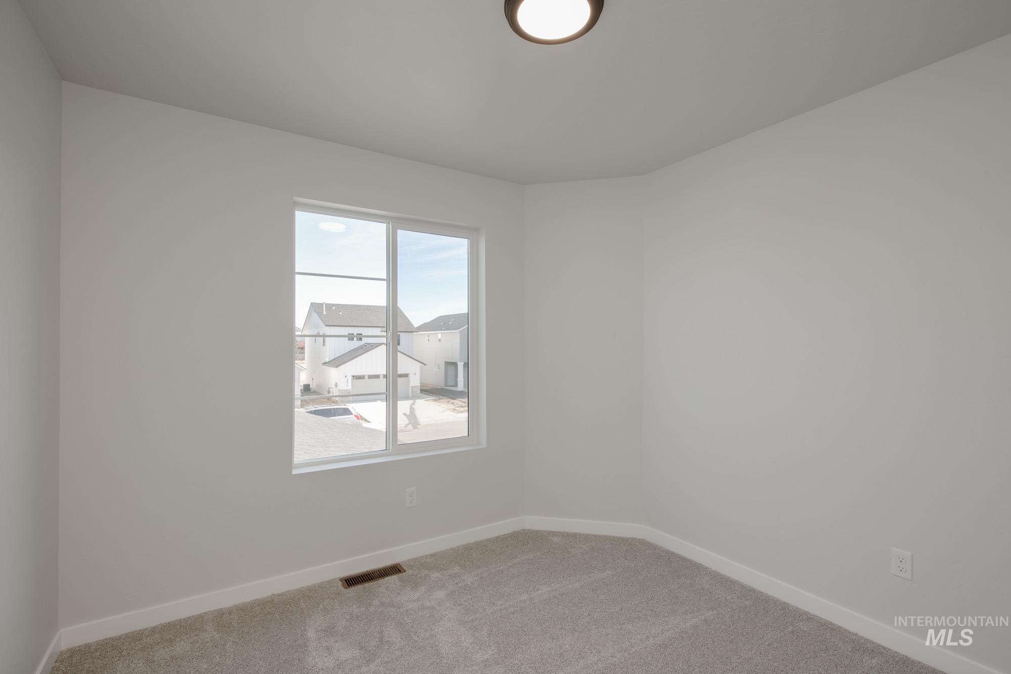 Carpeted spare room with baseboards