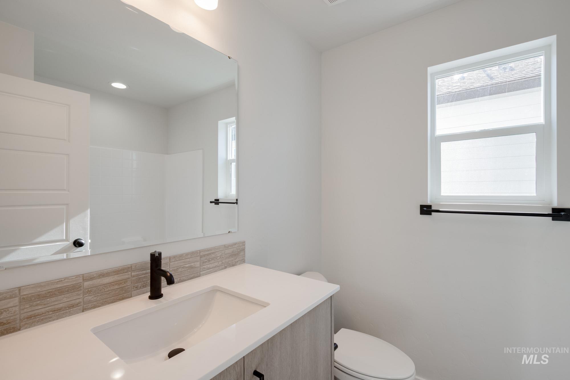 Bathroom featuring vanity and backsplash