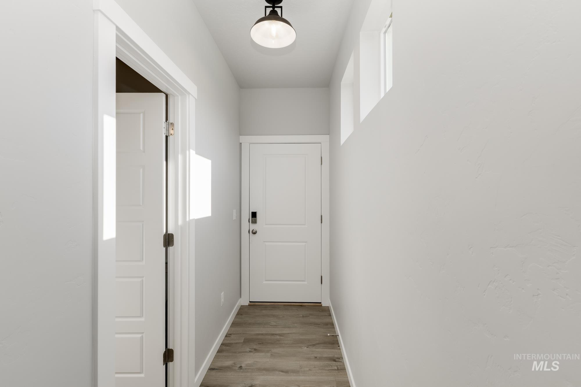 Hallway with baseboards and light wood-style flooring