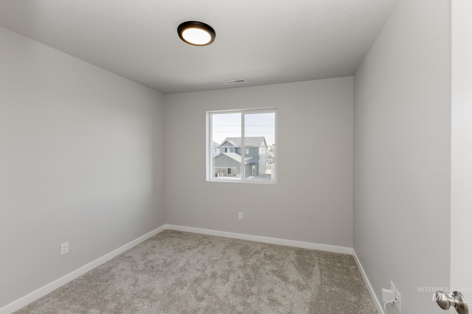 Carpeted empty room featuring baseboards