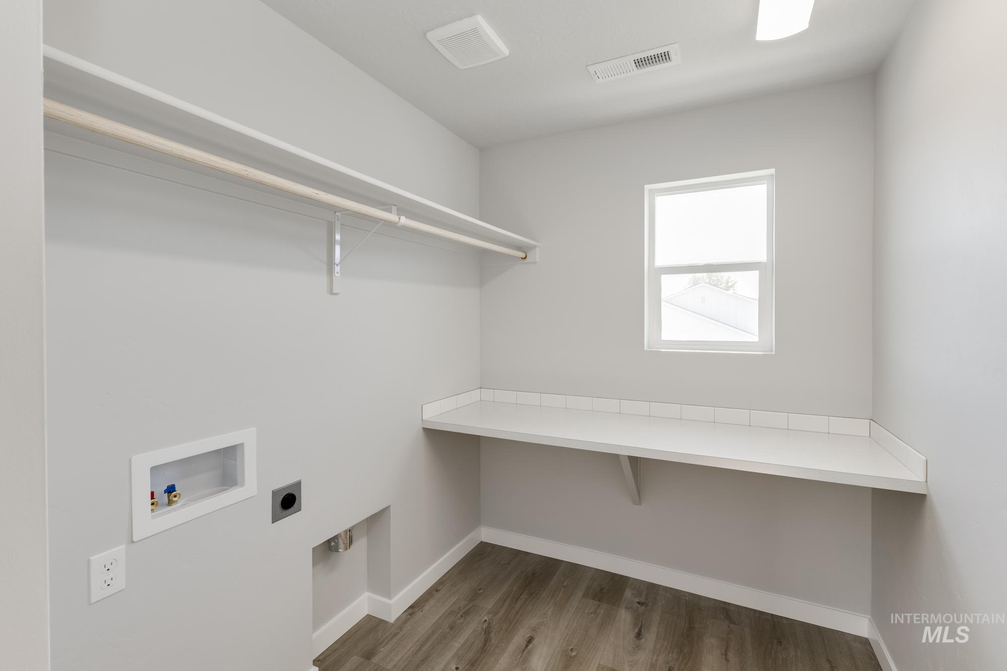 Laundry area featuring light wood-style floors, hookup for an electric dryer, and hookup for a washing machine