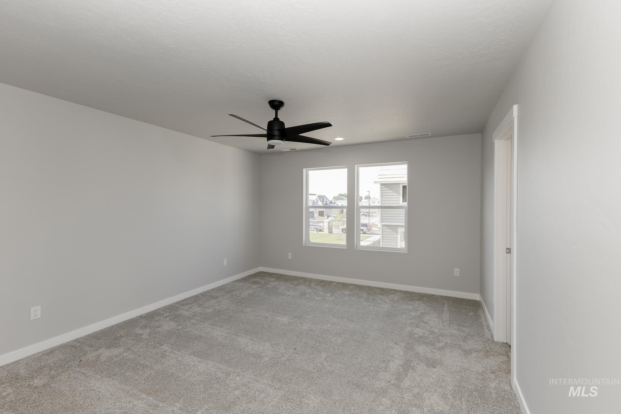 Unfurnished room with light colored carpet and a ceiling fan